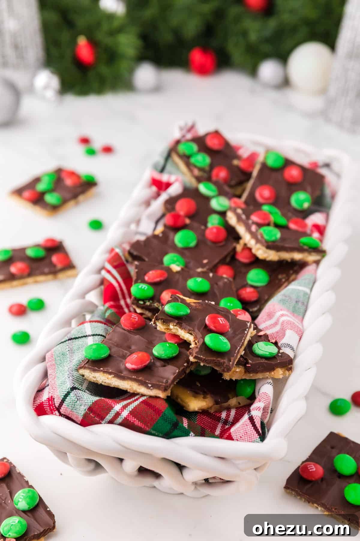 Irresistible Christmas Toffee Bark 4 Festive display of Christmas Crack served in a holiday-themed dish, adorned with red and green M&M's.