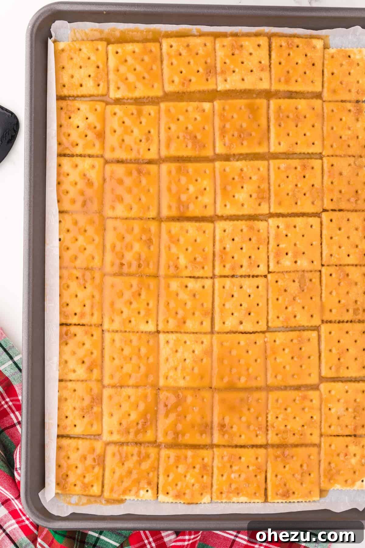 Irresistible Christmas Toffee Bark 10 Saltine crackers fully covered in baked, golden-brown toffee, fresh out of the oven.