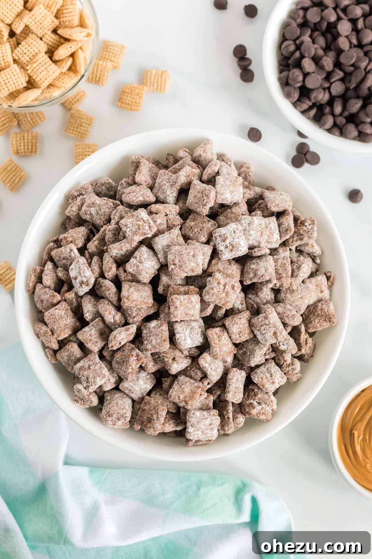 Vegan Chocolate Peanut Butter Cereal Crunch 10 Close-up of vegan puppy chow in a pristine white bowl, showcasing its powdered sugar coating