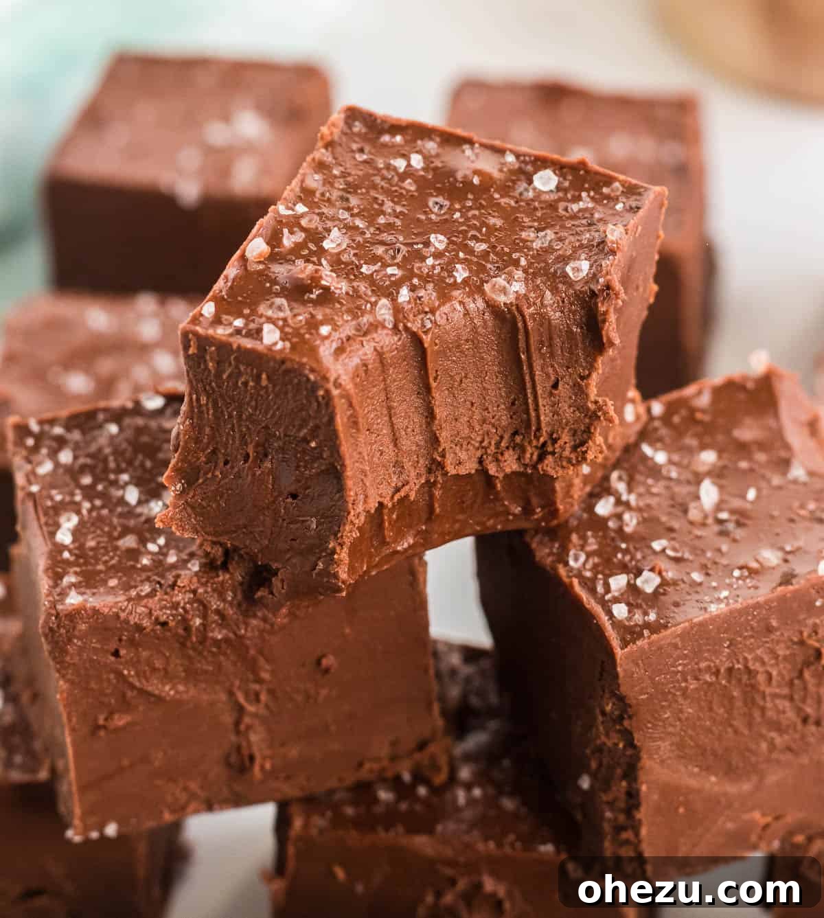 Decadent Vegan Peanut Butter Chocolate Fudge 2 Stacked pieces of creamy vegan chocolate peanut butter fudge, glistening with a sprinkle of sea salt, ready to be enjoyed.