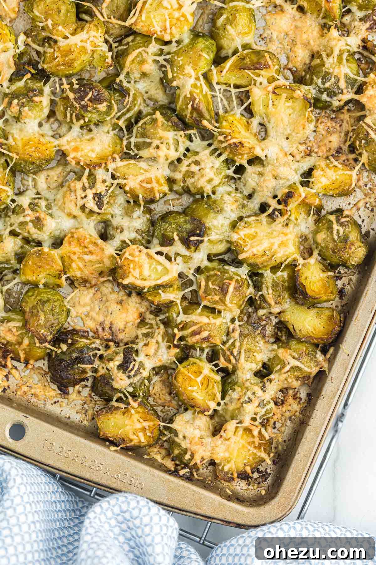 Crispy roasted frozen Brussels sprouts generously topped with melted golden Parmesan cheese, ready to serve as a delicious side dish.