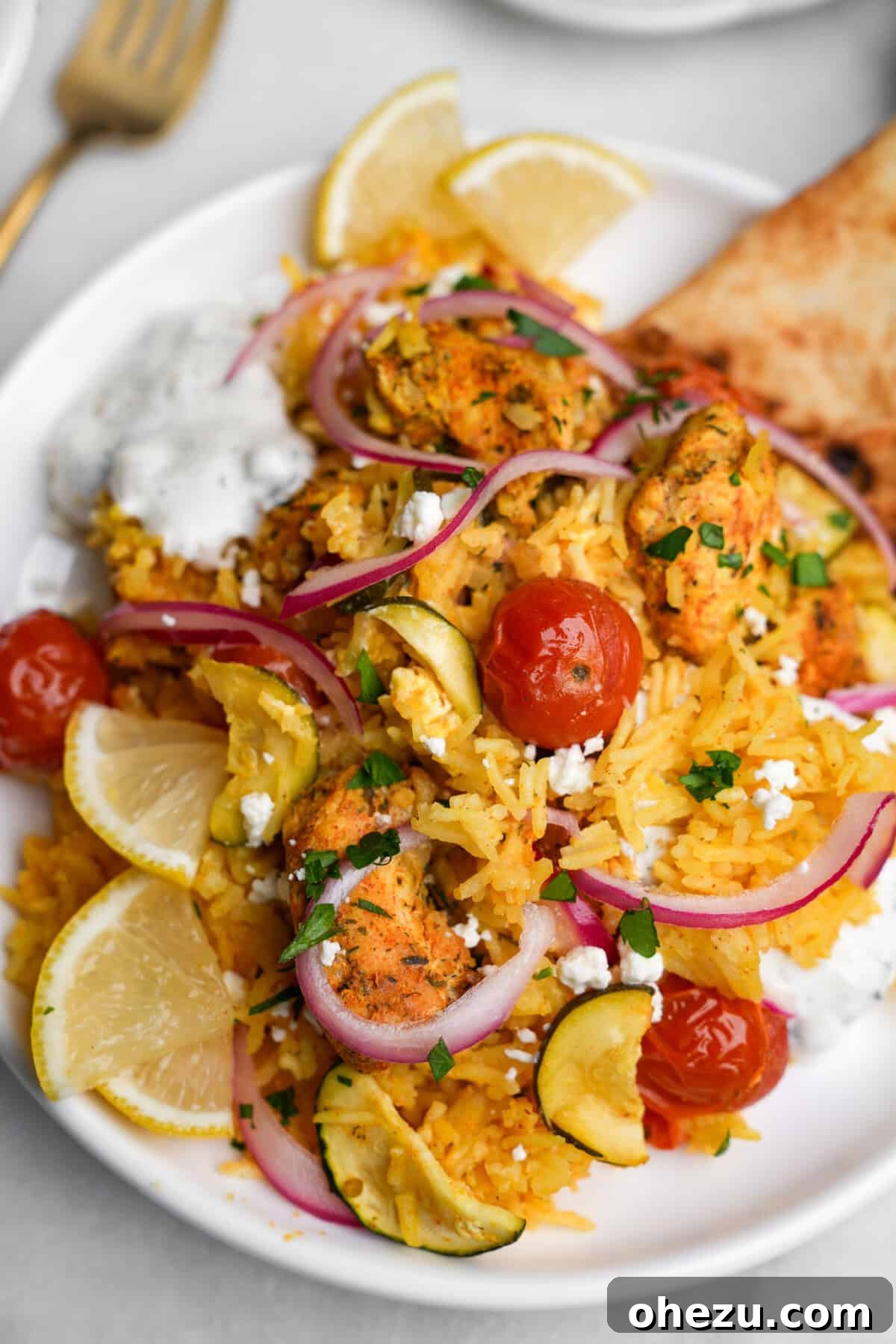 Zesty Greek Chicken Casserole 15 A single serving of Chicken Tzatziki Casserole on a plate, garnished with fresh herbs and a dollop of sauce.