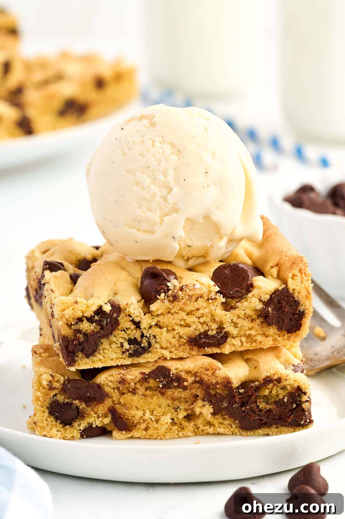 A serving of cake mix cookie bars topped with a scoop of vanilla ice cream