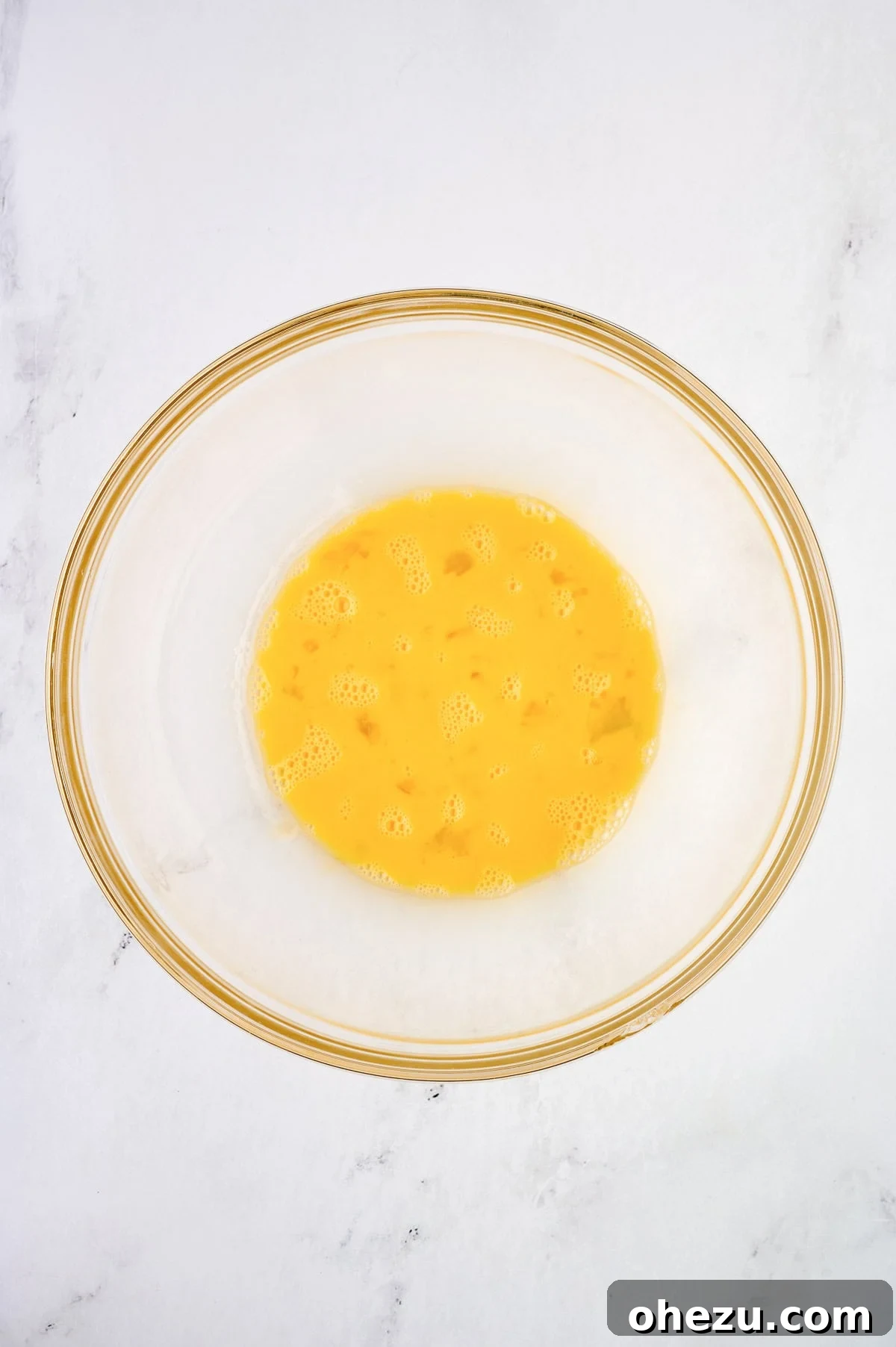 Whisked eggs in a mixing bowl, ready for other ingredients