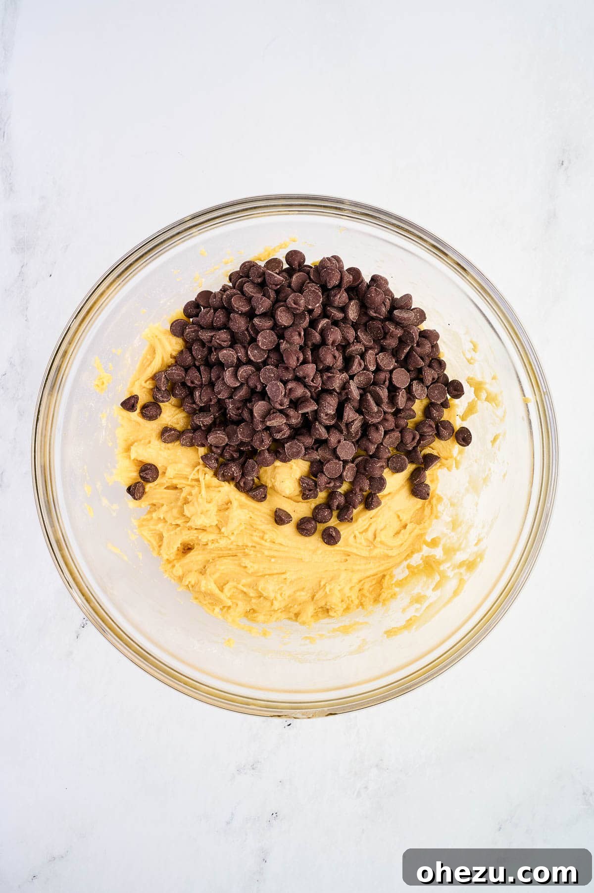Chocolate chips being added to the thick cake mix batter