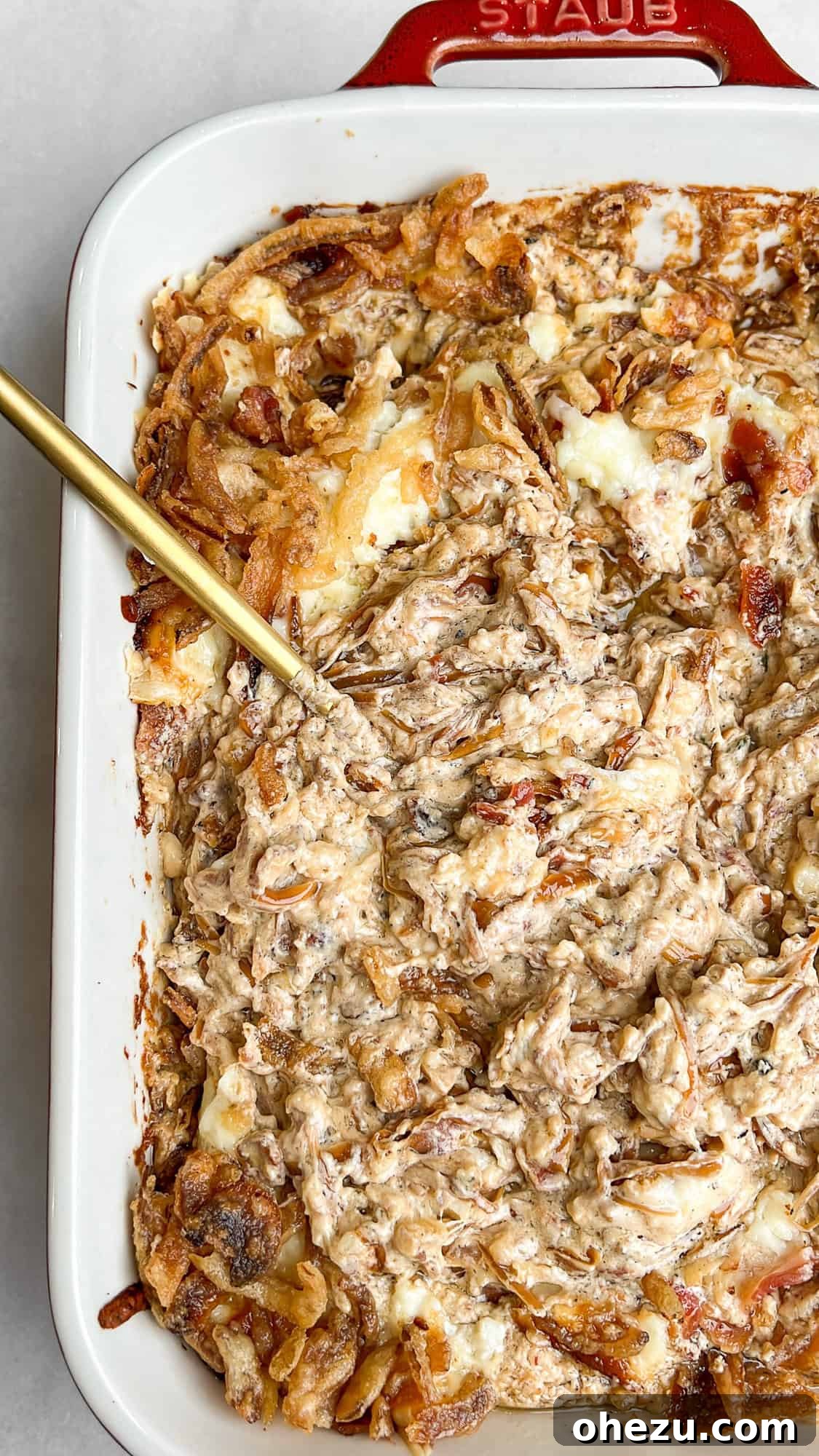 Caramelized onion dip with bacon and melted cheese in a pan, ready to be served