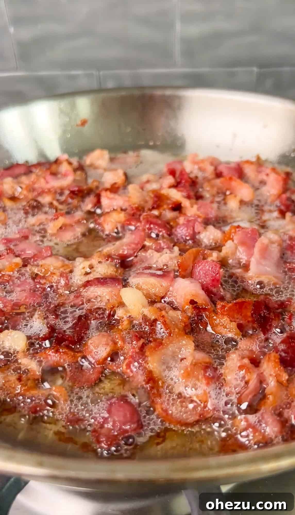 Bacon cooking in a cast iron pan, turning crispy