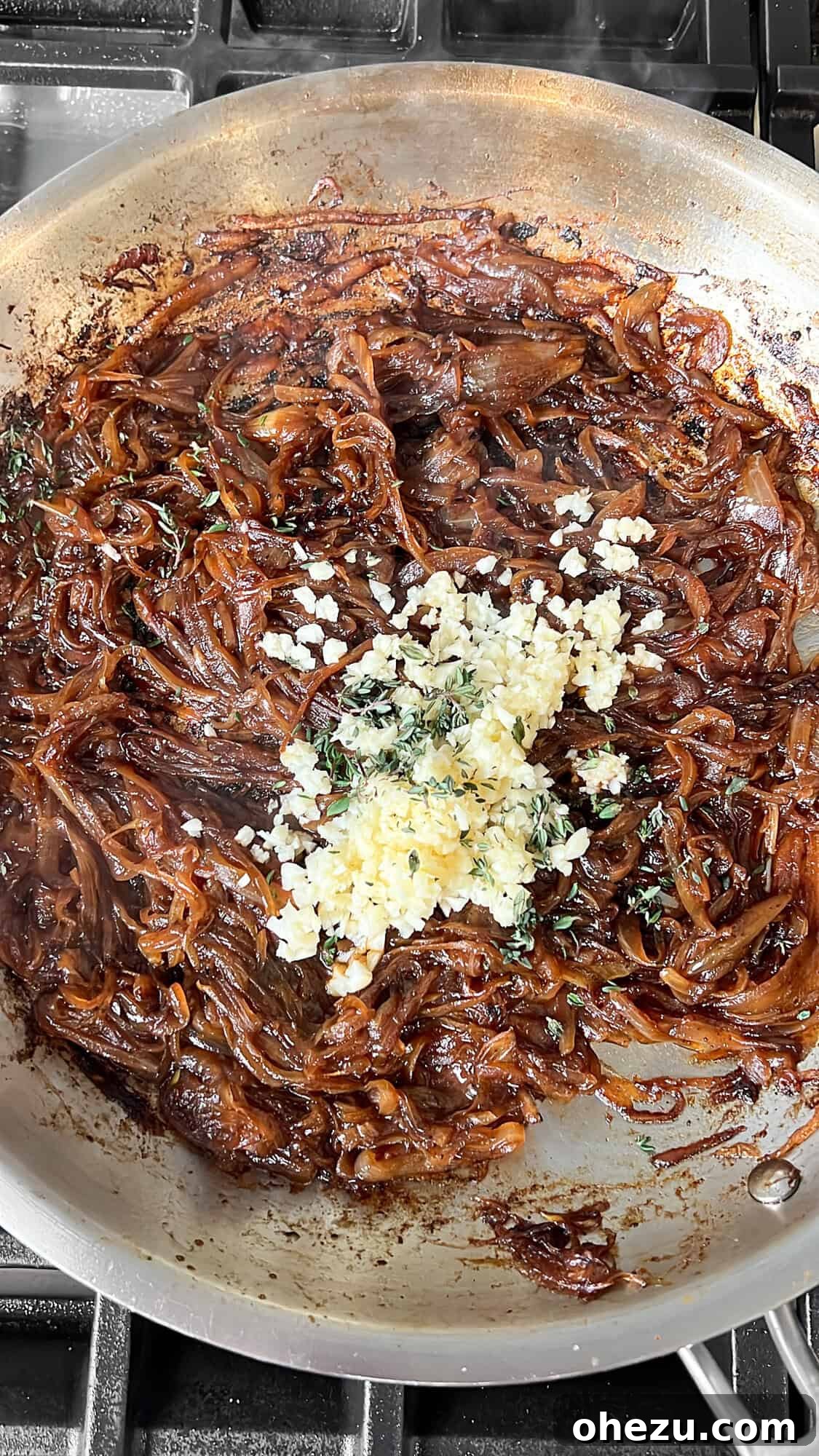 Caramelized onions in the pan with freshly added garlic and thyme