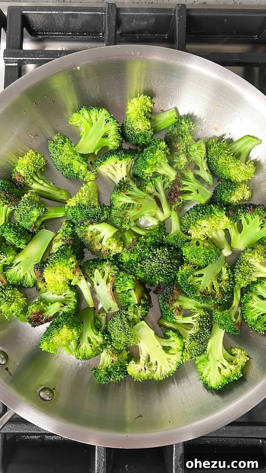 Fresh broccoli florets sautéing in a hot skillet