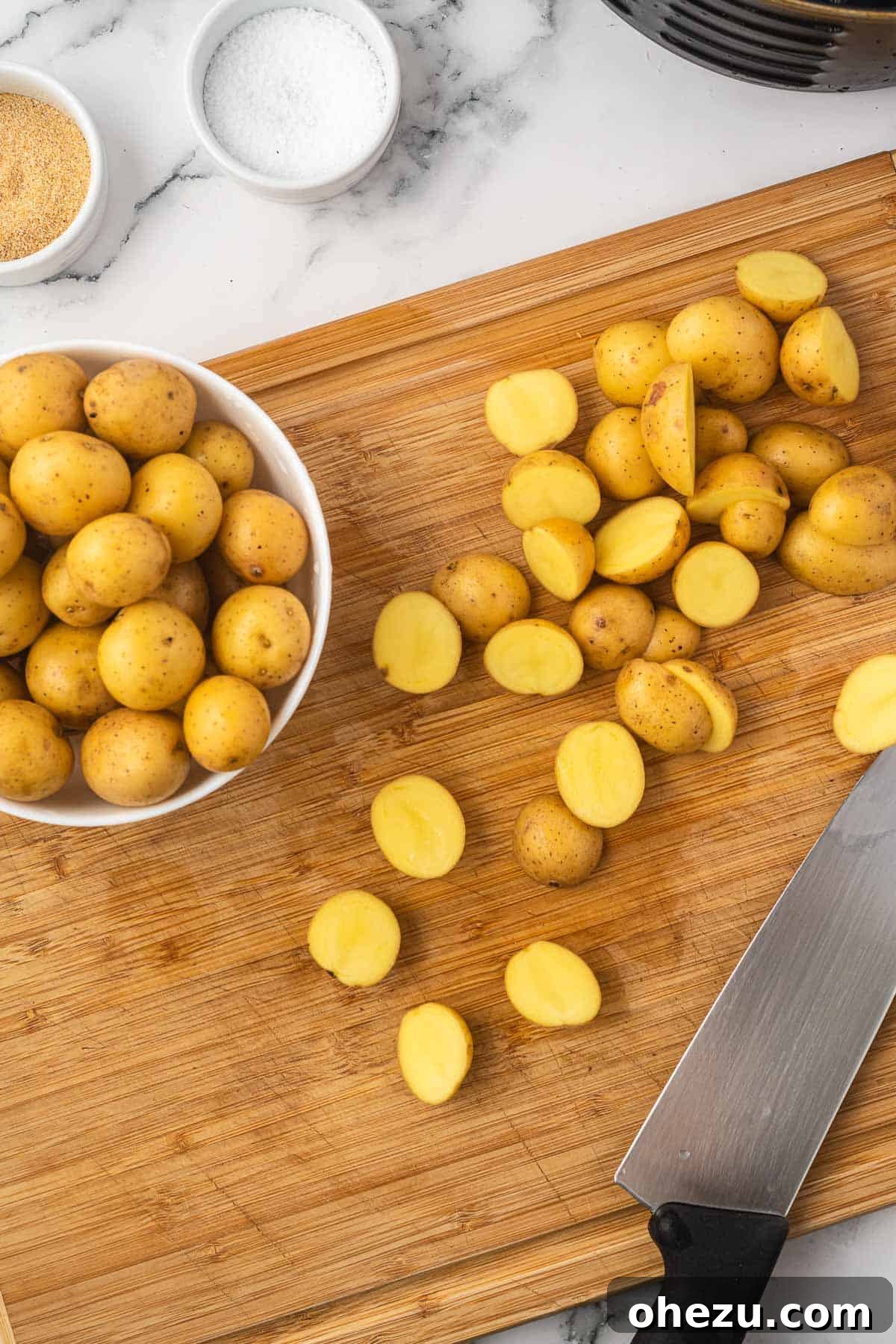 Crispy Air Fryer Baby Potatoes 5 baby potatoes cut in half on a cutting board