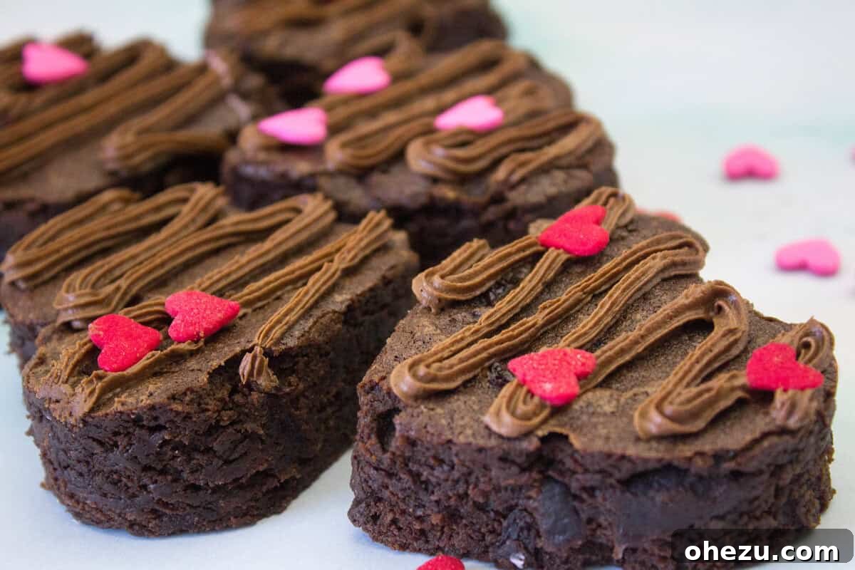 Overhead view of several heart-shaped Cherry Chocolate Valentine Brownies arranged on a white platter.