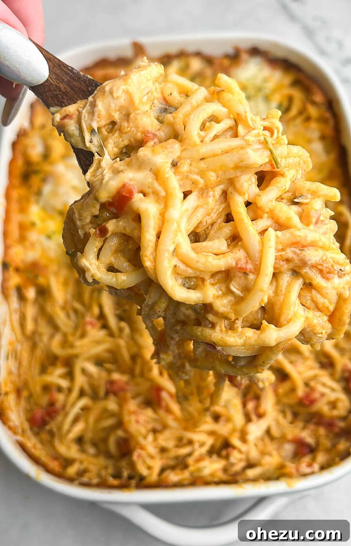 chicken spaghetti being lifted on a serving spoon