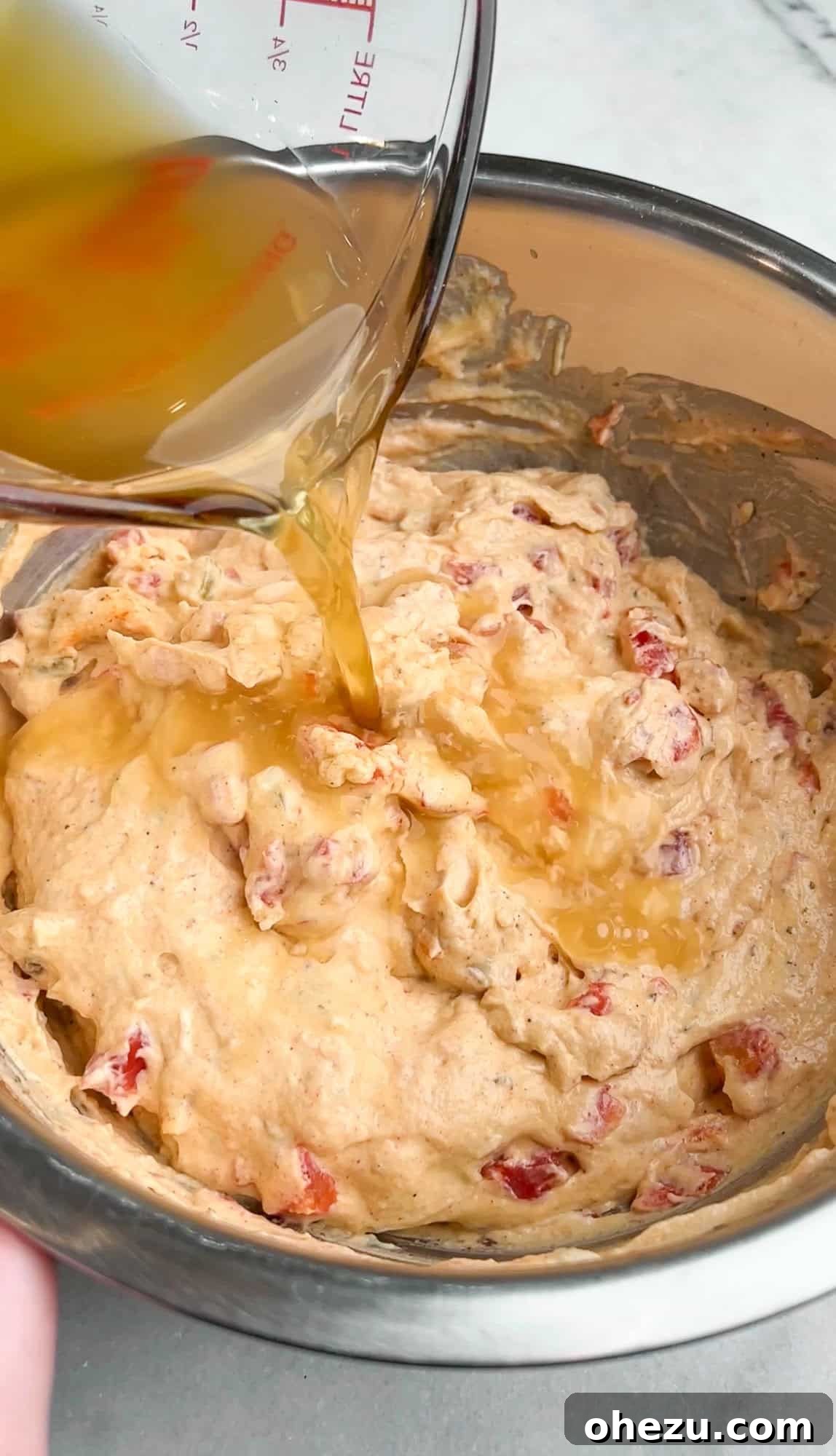 chicken stock pouring into the cream sauce