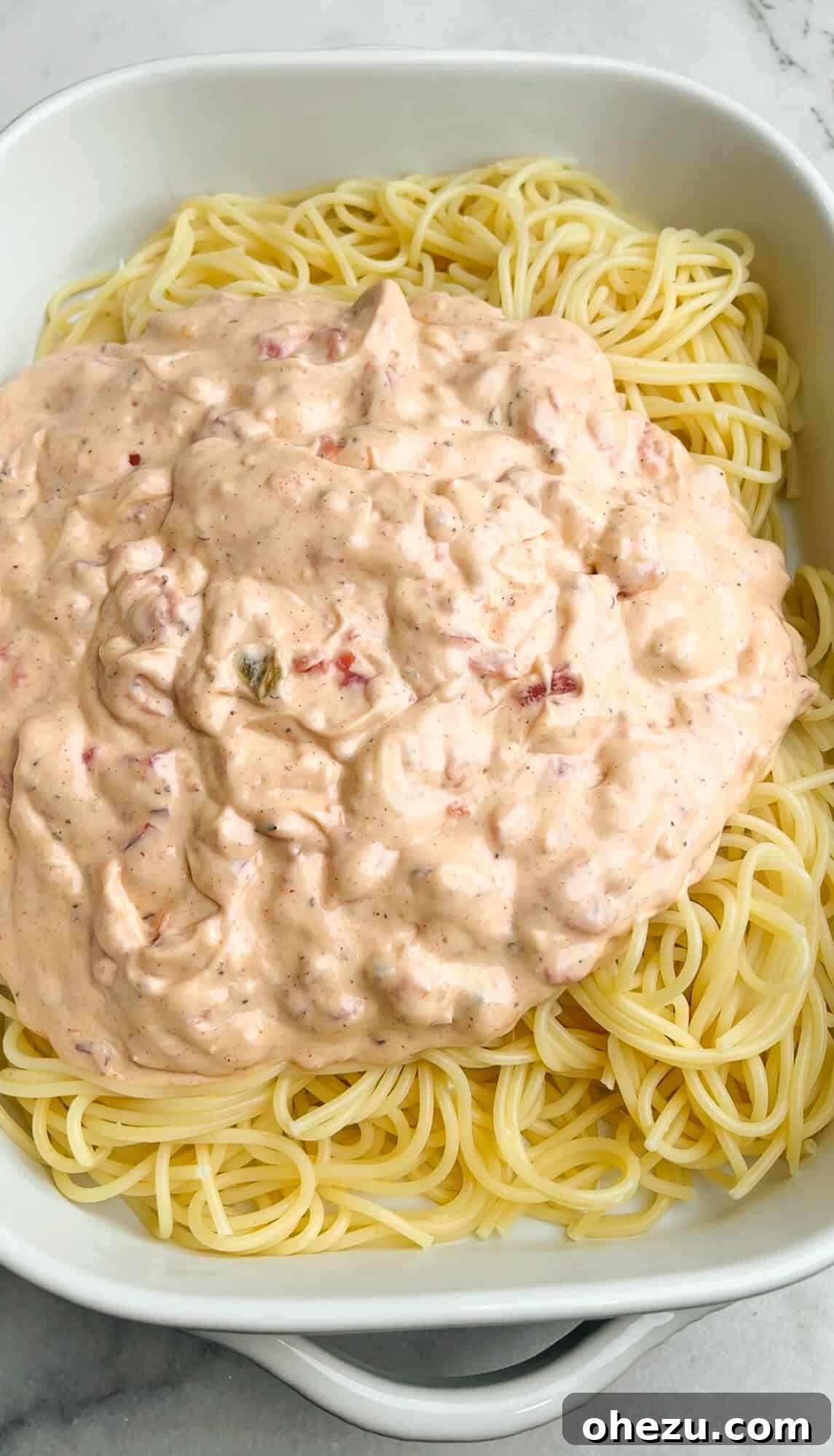 spaghetti and cream sauce in a casserole dish