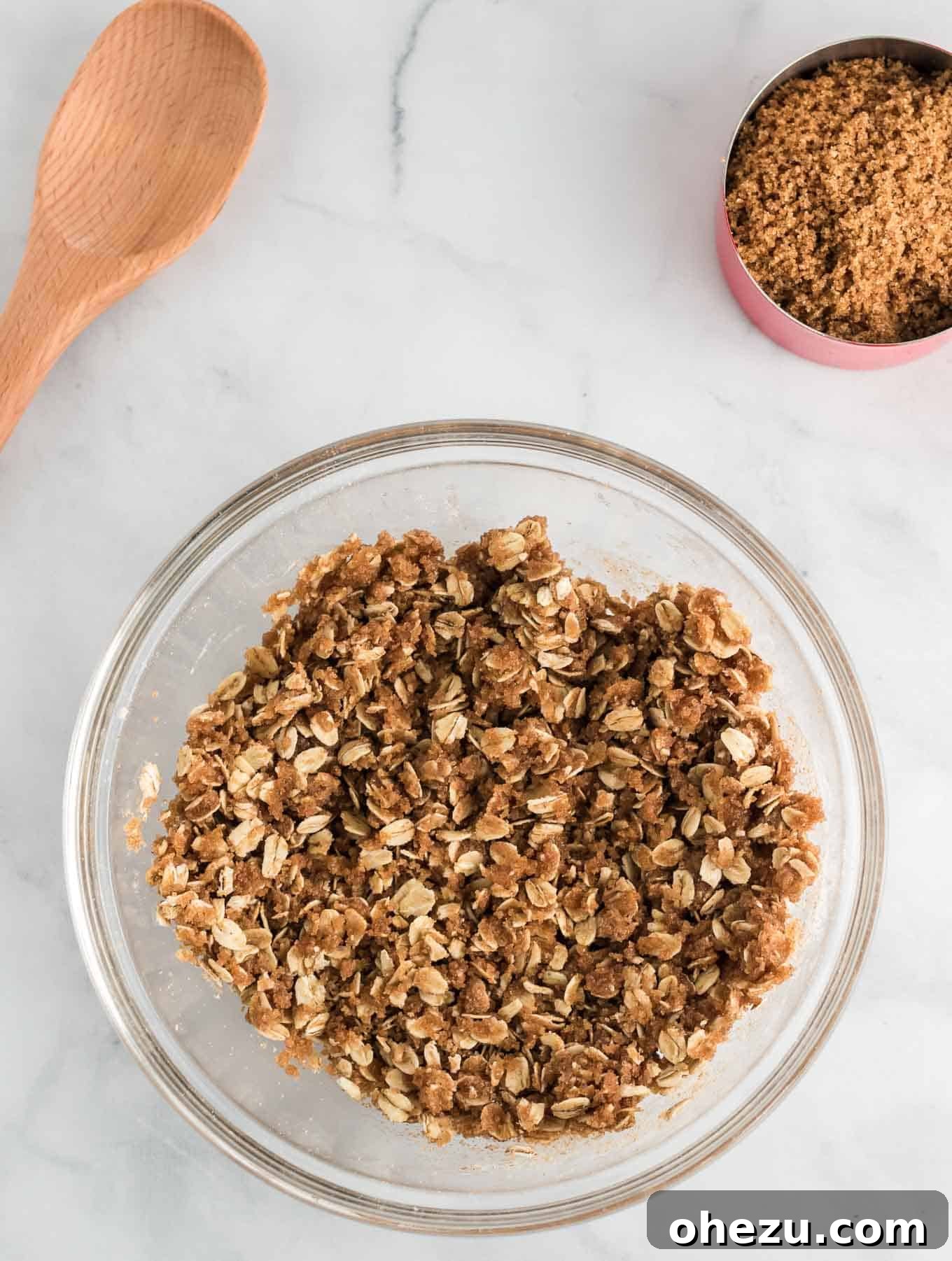The crisp topping mixture, resembling wet sand, ready for baking in a mixing bowl