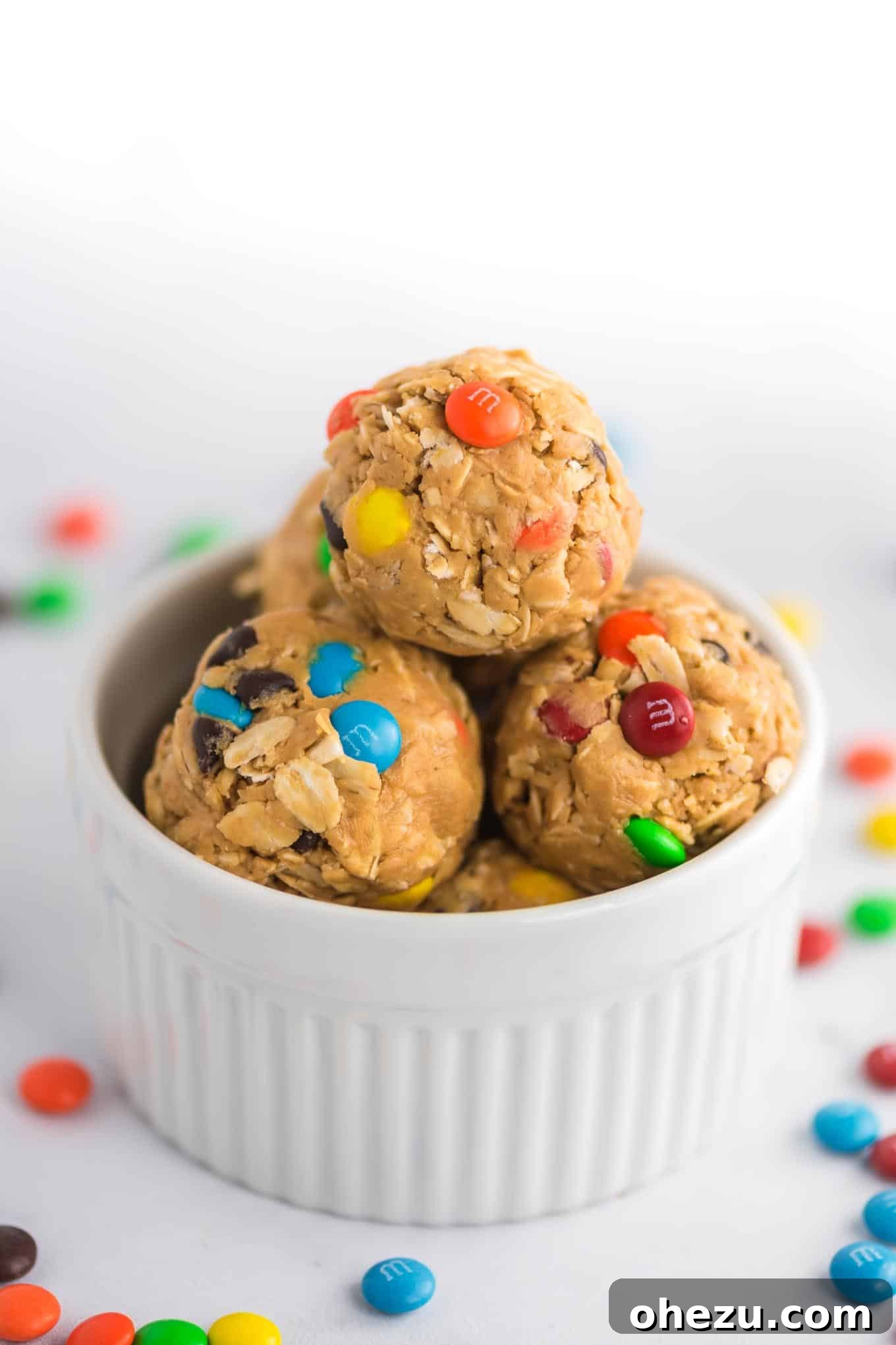 Ultimate Monster Cookie Fuel Bites 2 Vibrant monster cookie energy balls with colorful mini M&M's peeking out, arranged appetizingly.