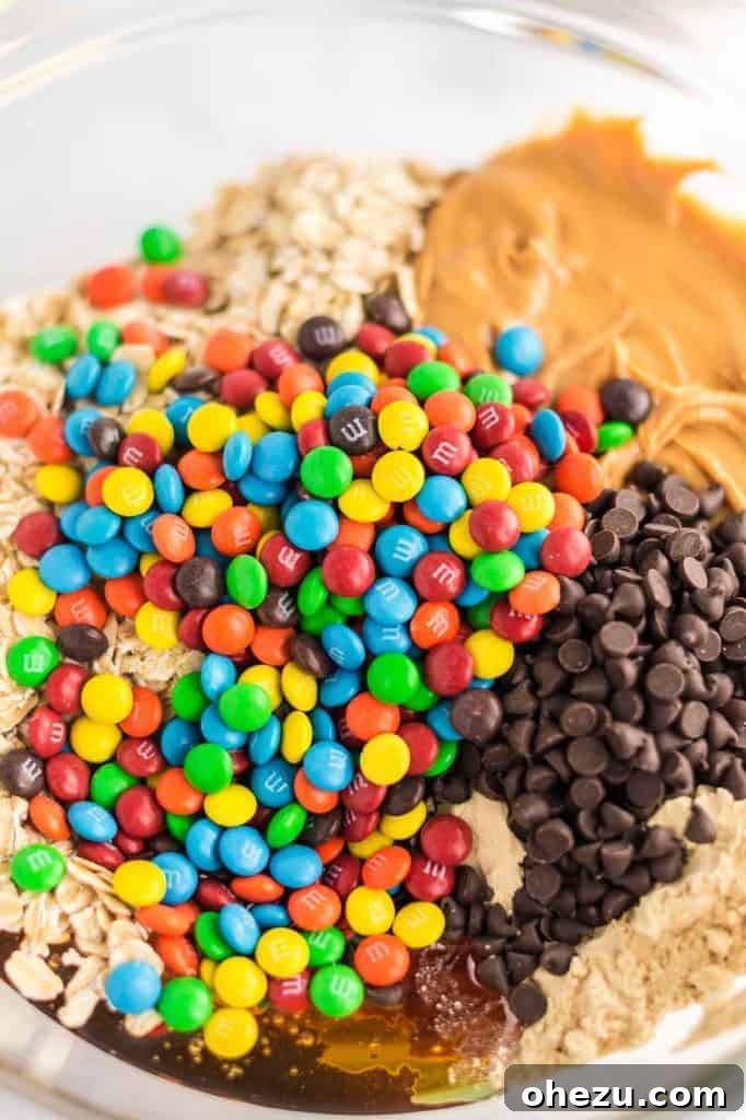 Ultimate Monster Cookie Fuel Bites 6 Close-up view of mini M&M's and chocolate chips mixed into the energy ball batter in a bowl.