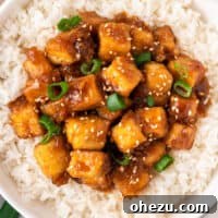 Orange tofu over rice in a bowl