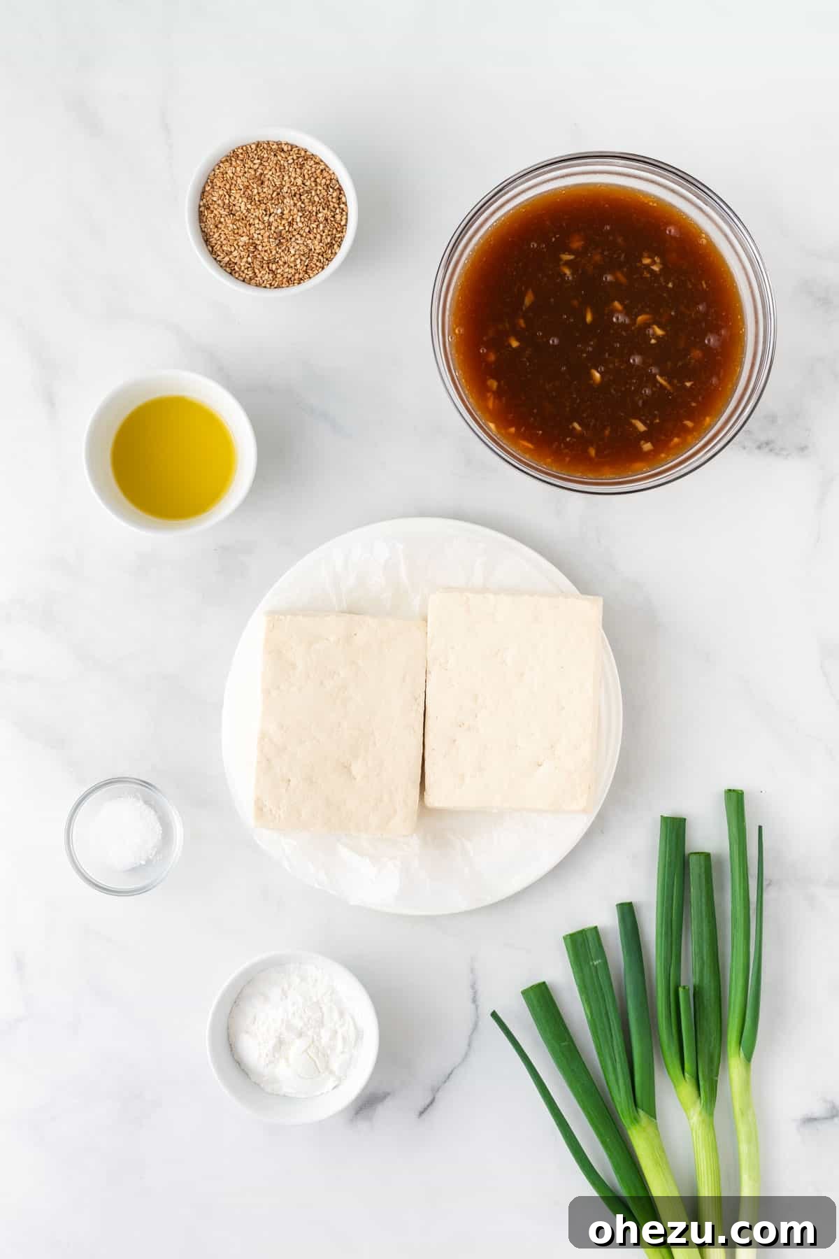 All the fresh ingredients required for making crispy orange tofu, neatly laid out on a kitchen counter.