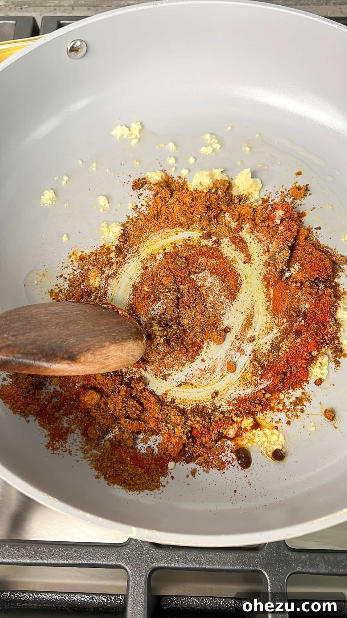 Effortless Butter Chicken 6 The array of colorful seasonings being gently mixed into the pan, creating a fragrant paste.