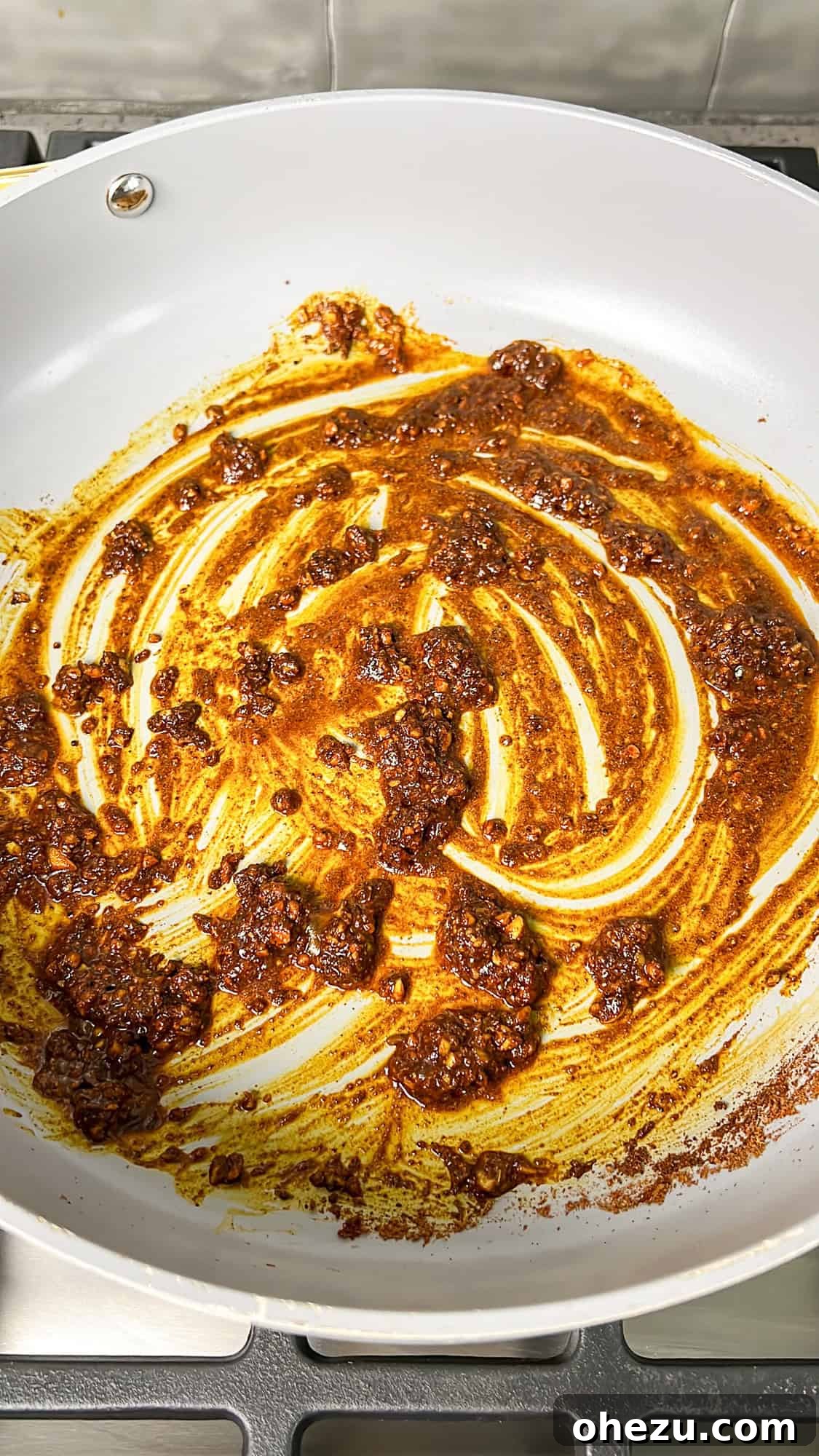 Effortless Butter Chicken 7 The fragrant spice and garlic mixture lightly sautéing in olive oil within a skillet.