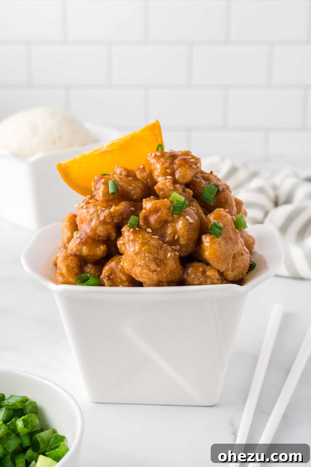 Baked orange cauliflower in a takeout box, ready to be enjoyed, highlighting its takeout resemblance