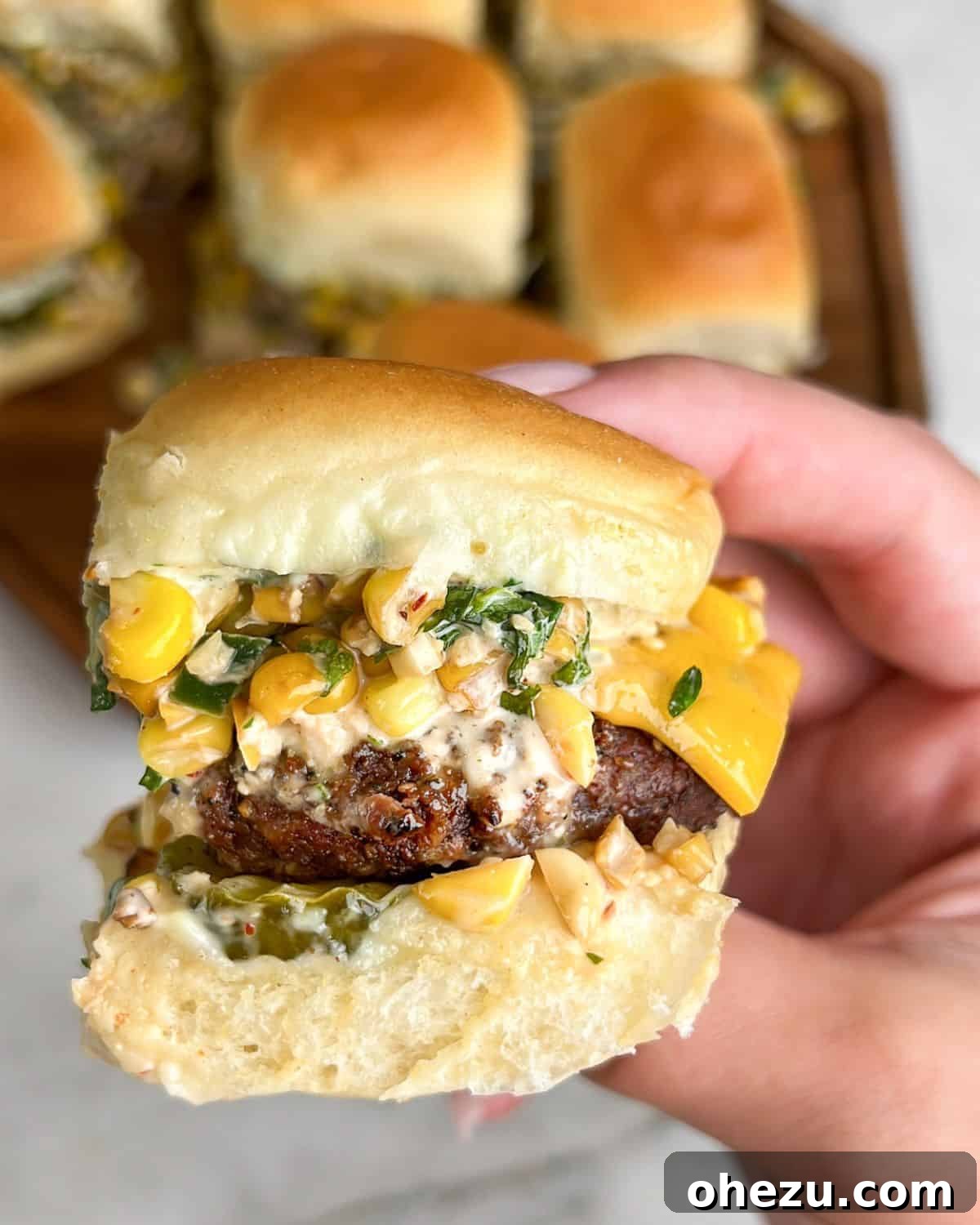 cheeseburger sliders being held in hand