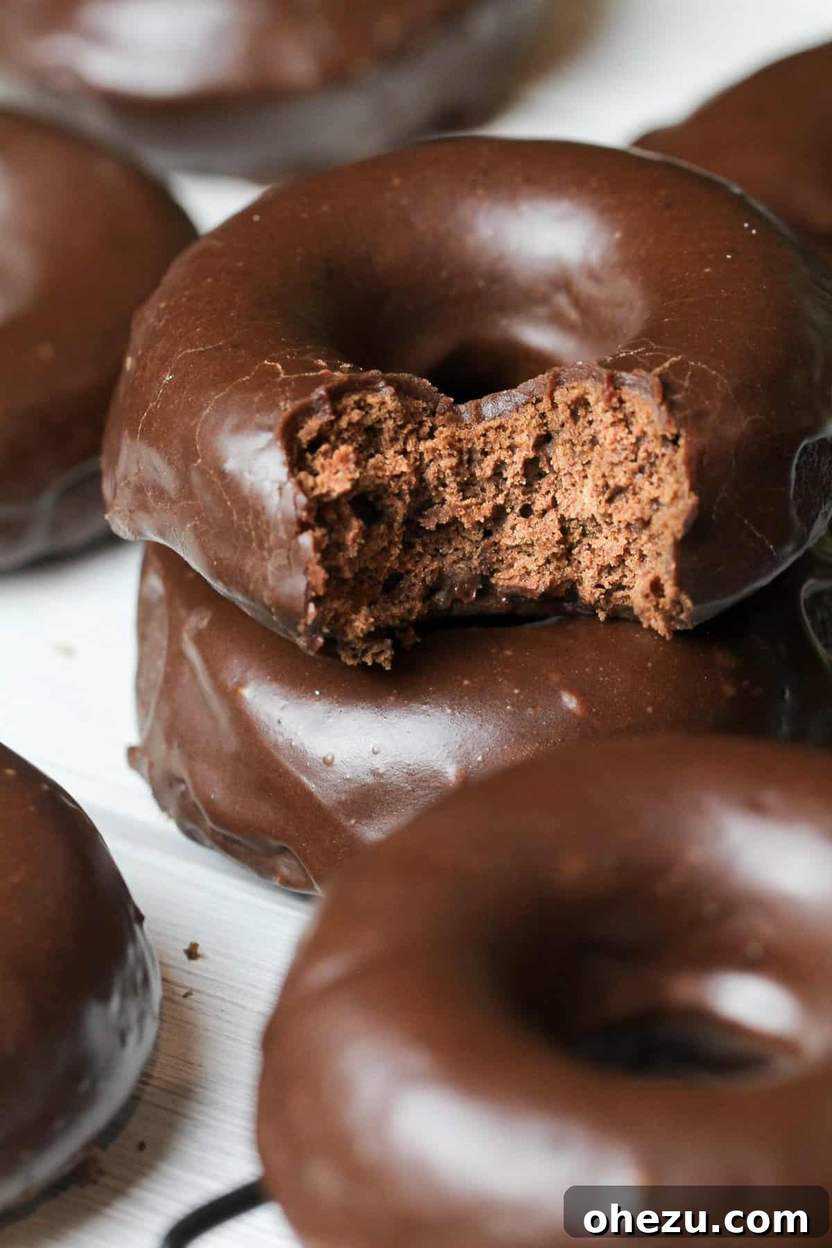 Entenmann's style chocolate glazed donuts on a cooling rack