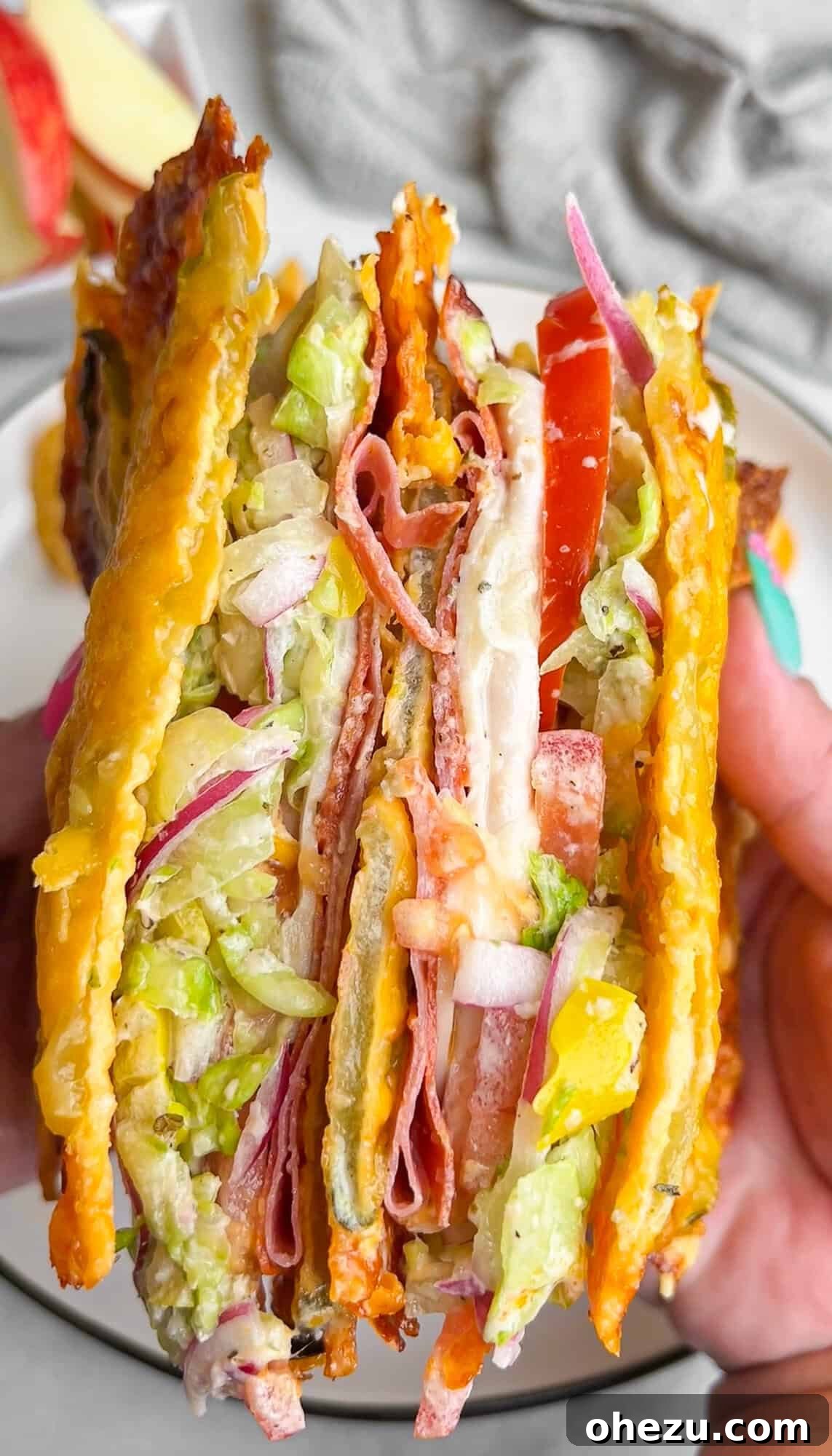 An enticing cross-section view of a Viral Pickle Sandwich, revealing layers of savory deli meats and a fresh, creamy Italian Grinder salad nestled between two crispy cheese-pickle 'bread' slices.