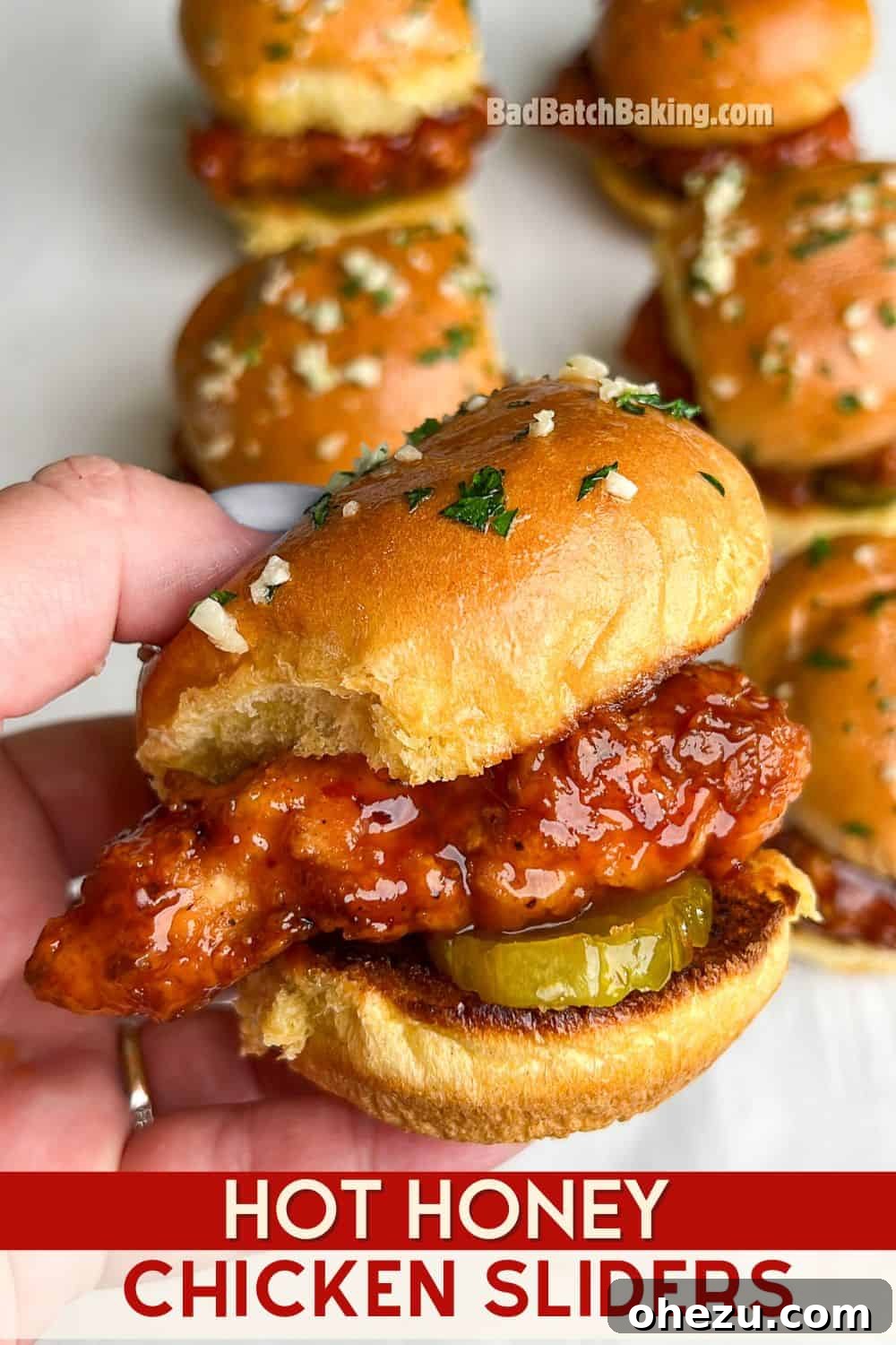 A close-up shot of a hand holding a Hot Honey Chicken Slider, emphasizing the delicious layers and crispy texture, ideal for a social media share.
