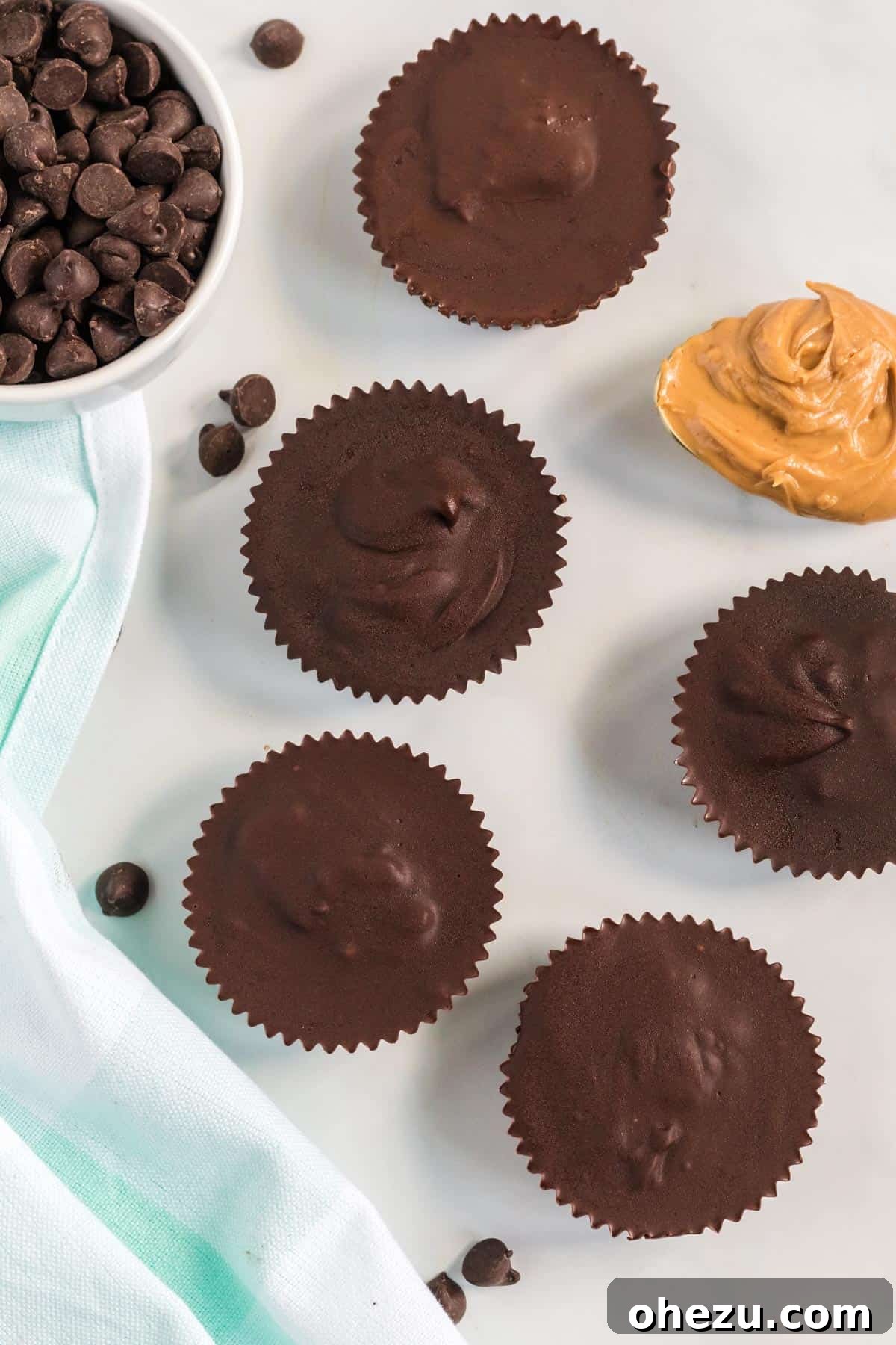 Decadent Vegan Peanut Butter Cups 3 peanut butter cups lined up next to a spoon of peanut butter