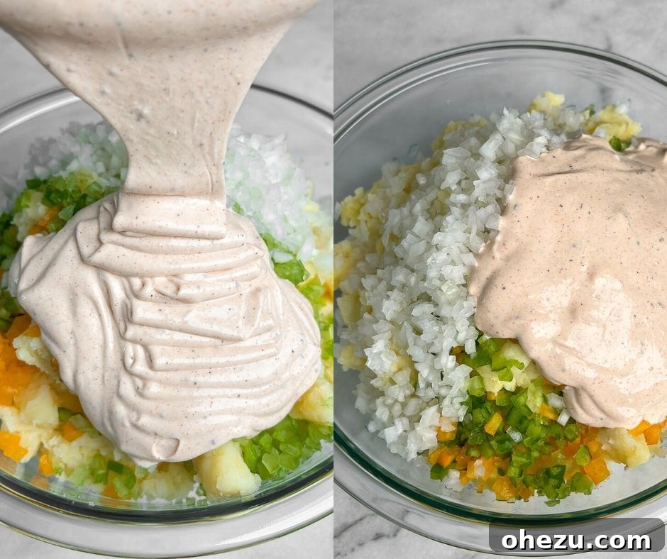 A large bowl of potato salad with no eggs, as the creamy dressing is poured over the top, ready to be mixed.