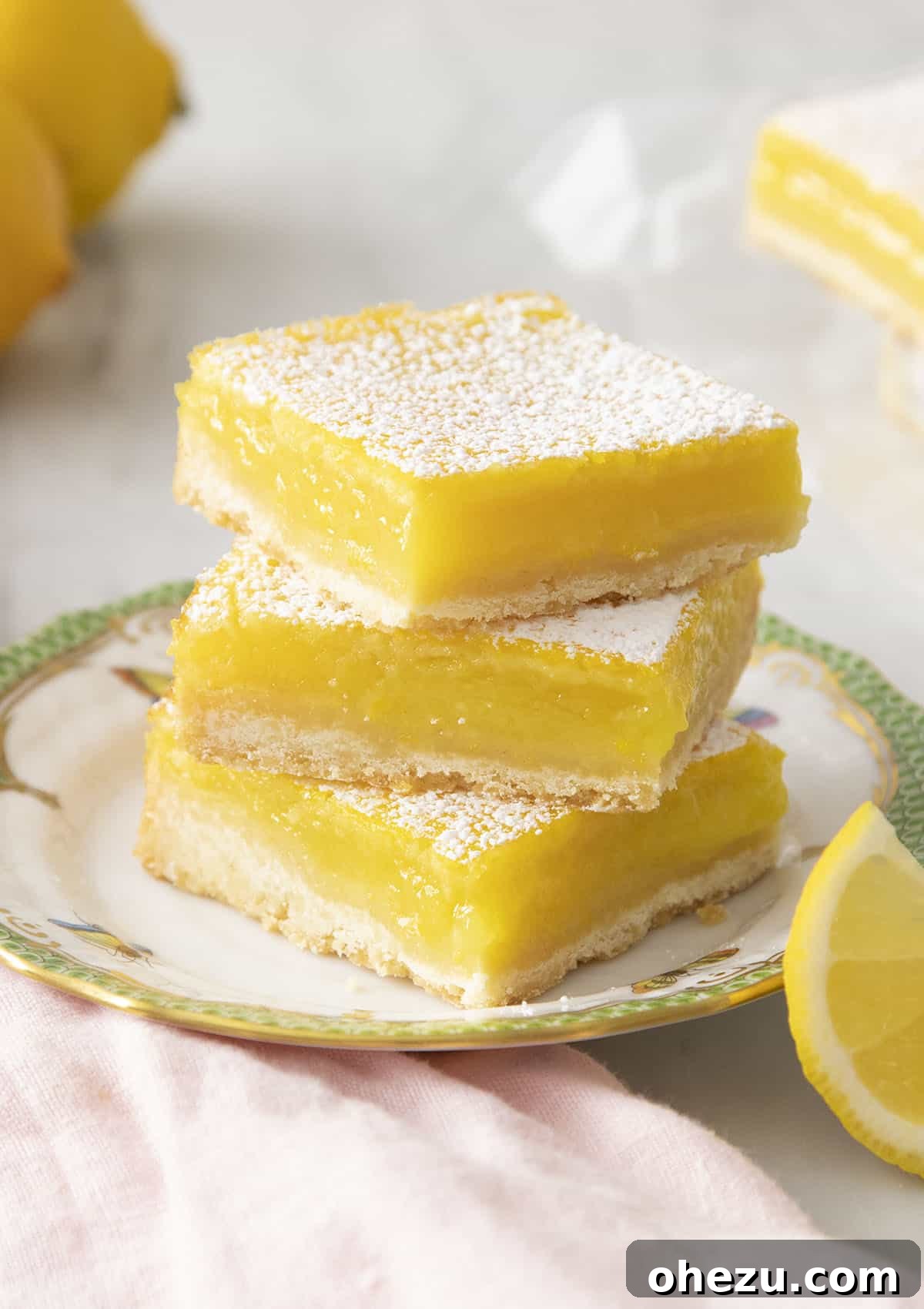 Classic Lemon Bars dusted with powdered sugar, arranged on a cooling rack.