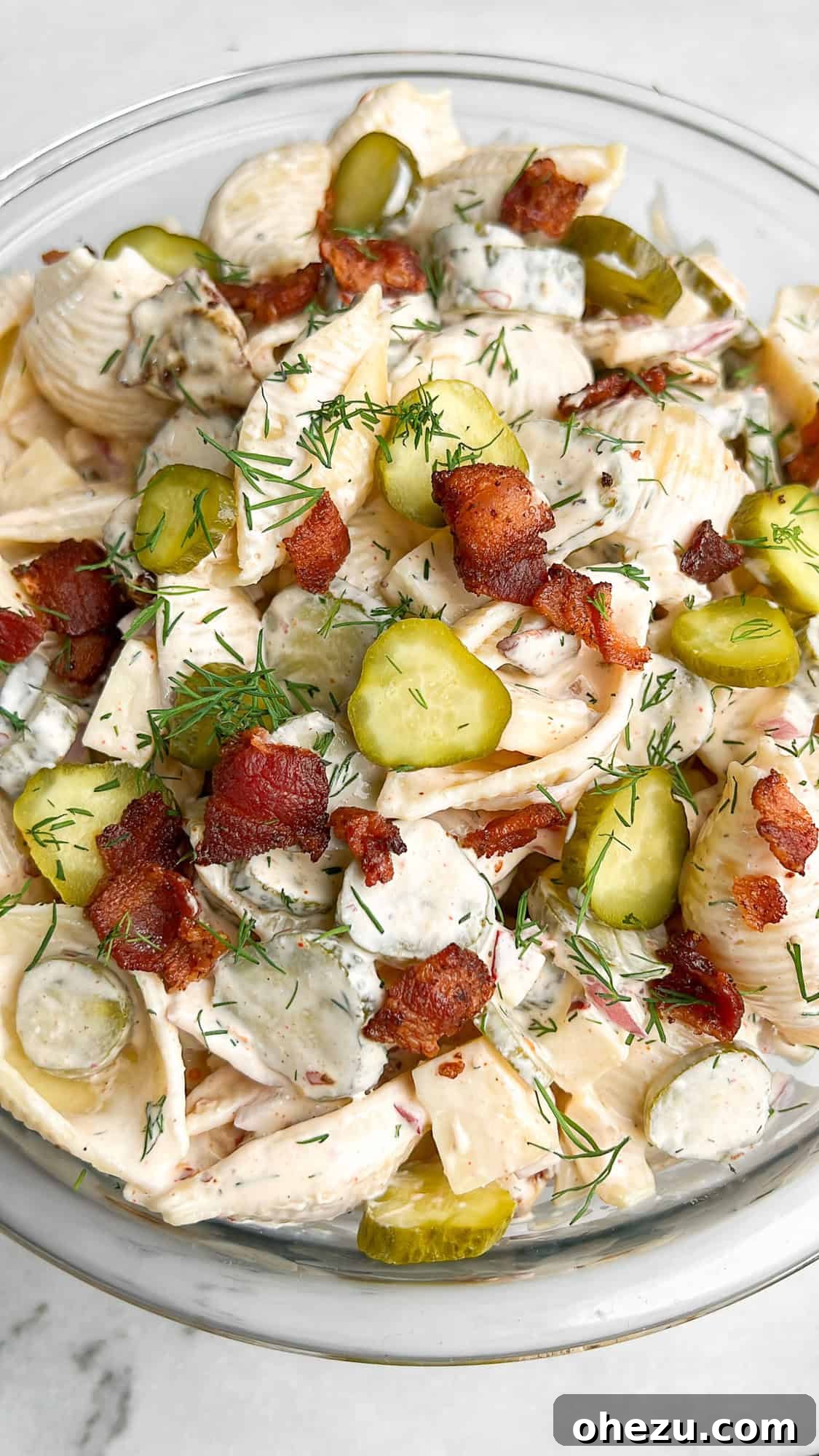 A large serving bowl of Creamy Bacon Dill Pickle Pasta Salad, ready to be enjoyed.