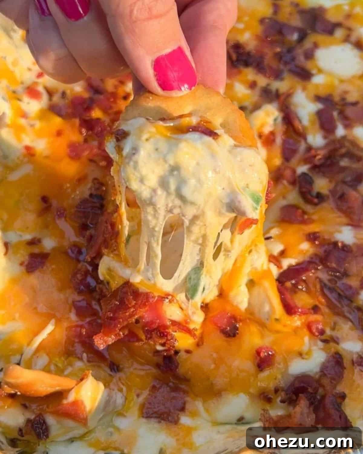 A pan of bubbling hot smoked jalapeno popper dip with crispy bacon and melted cheese.