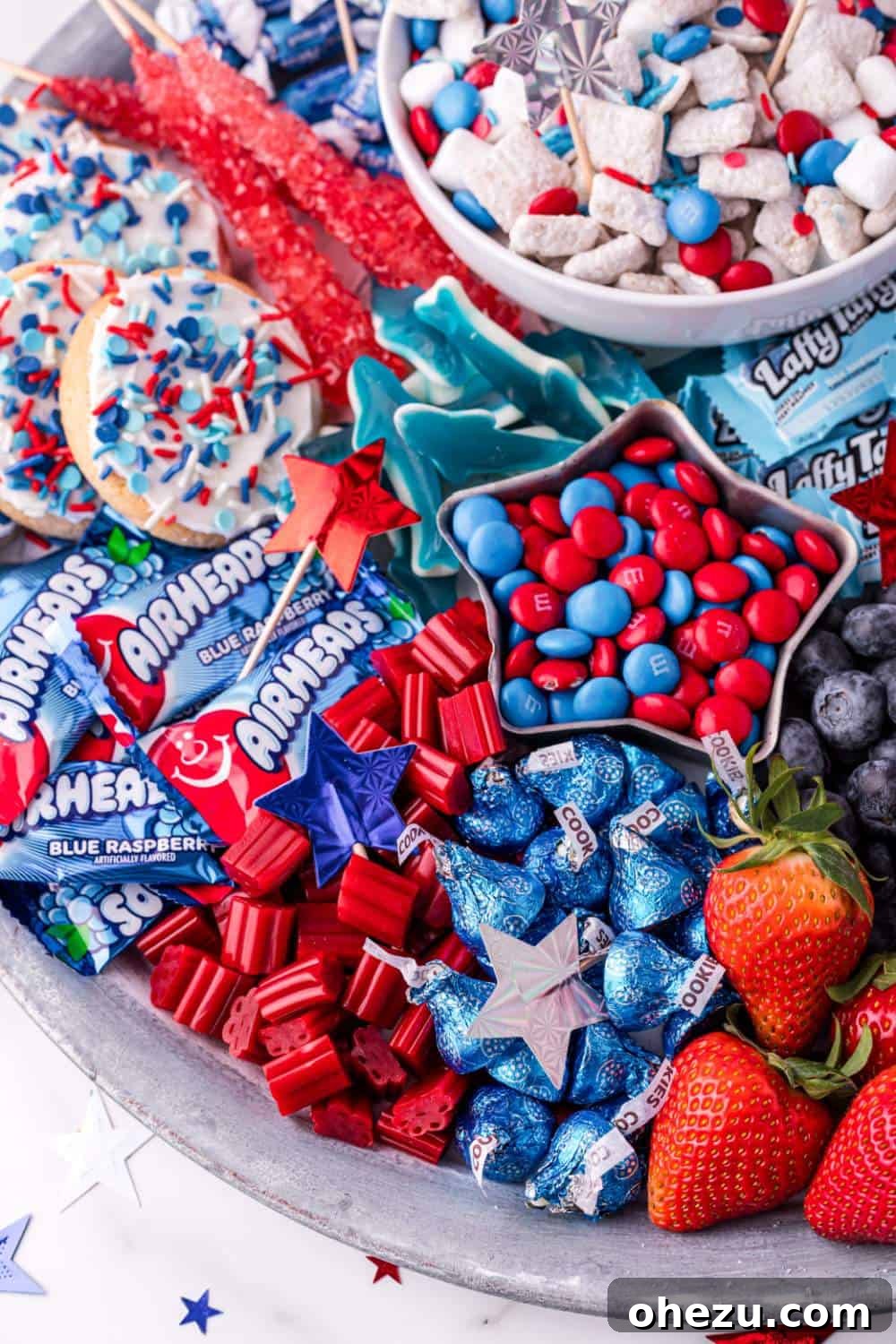 A festive 4th of July Sweet Charcuterie Board filled with red, white, and blue candies and fruits.