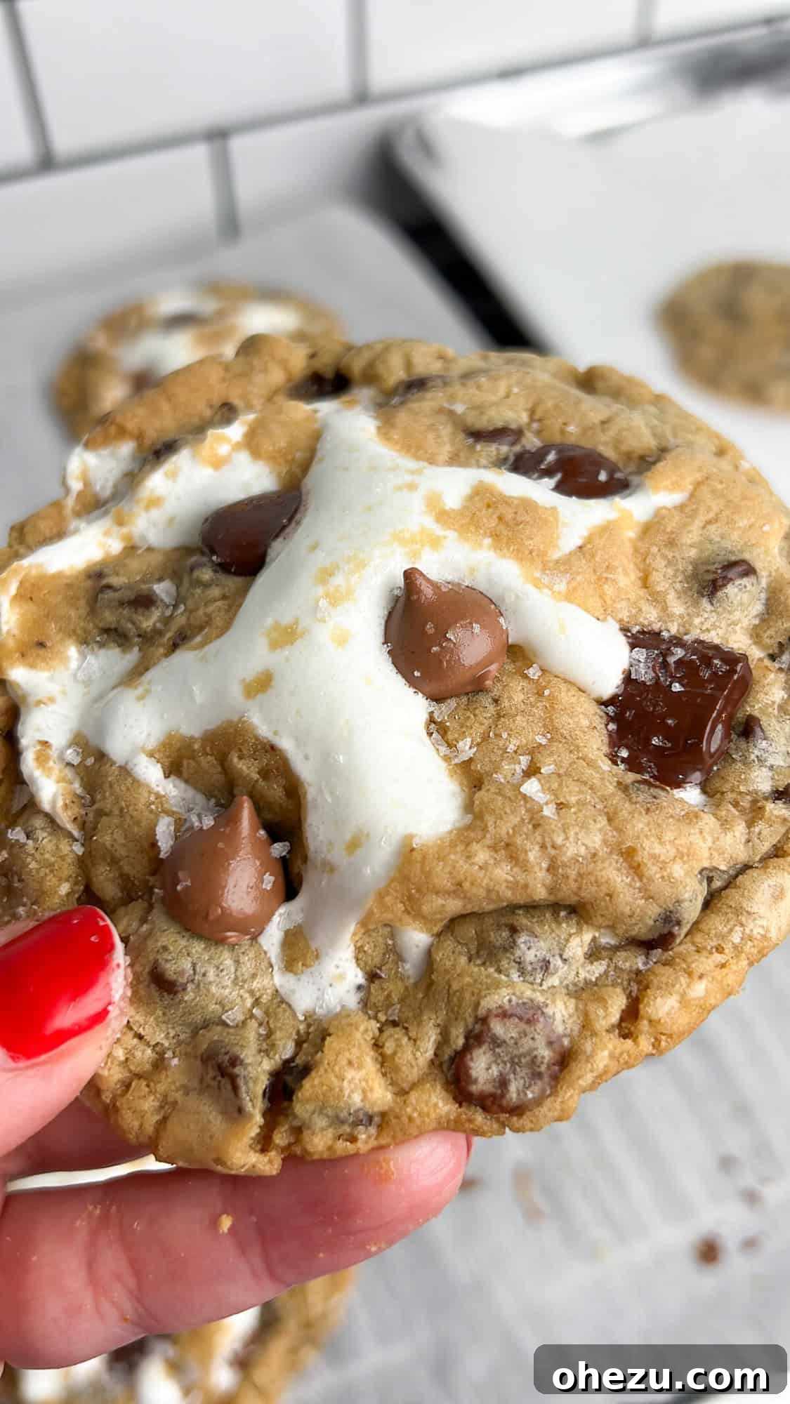 Close-up of S'mores Stuffed Chocolate Chip Cookies with melted marshmallow and chocolate.