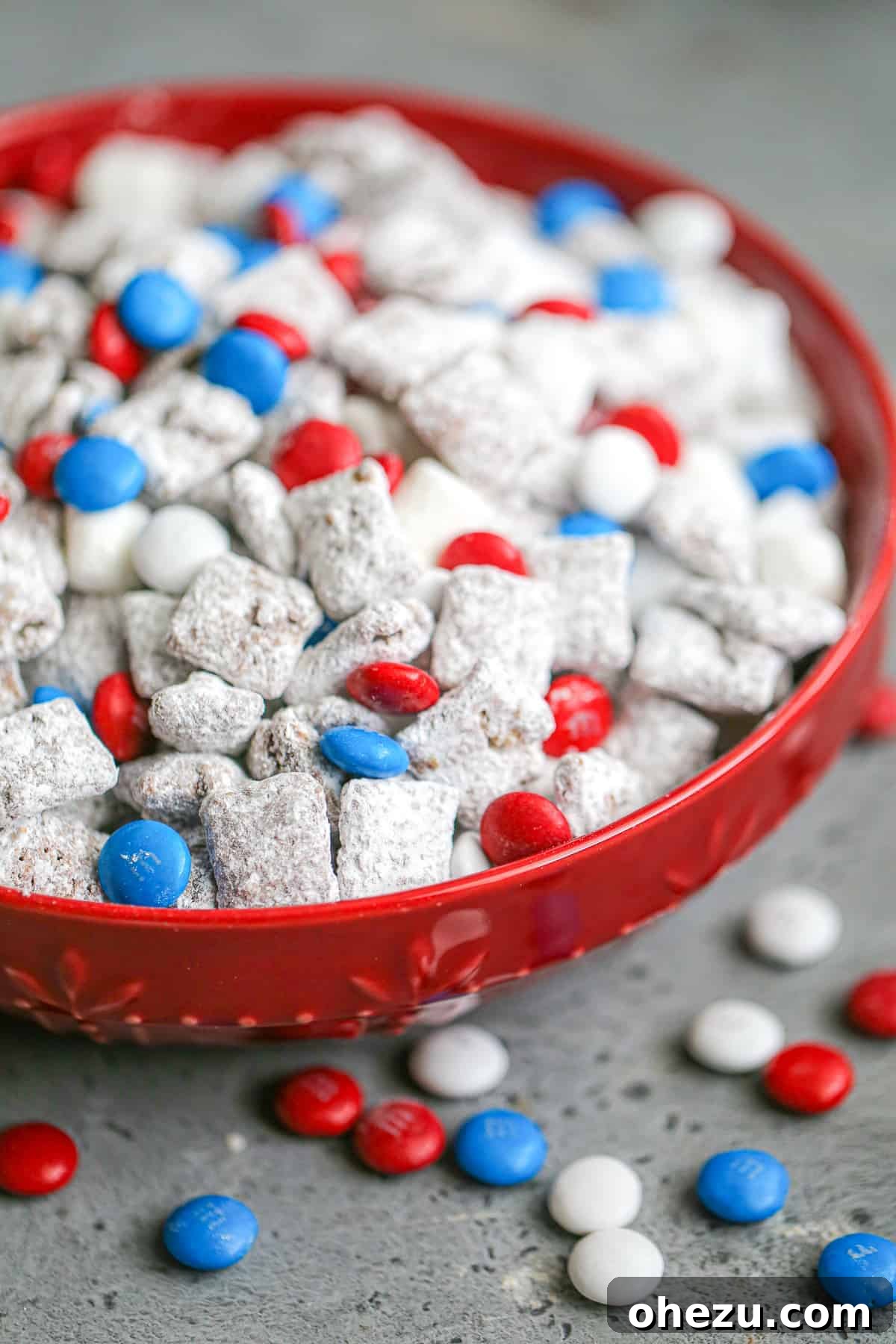 A bowl of colorful Patriotic Puppy Chow with red, white, and blue M&M's.