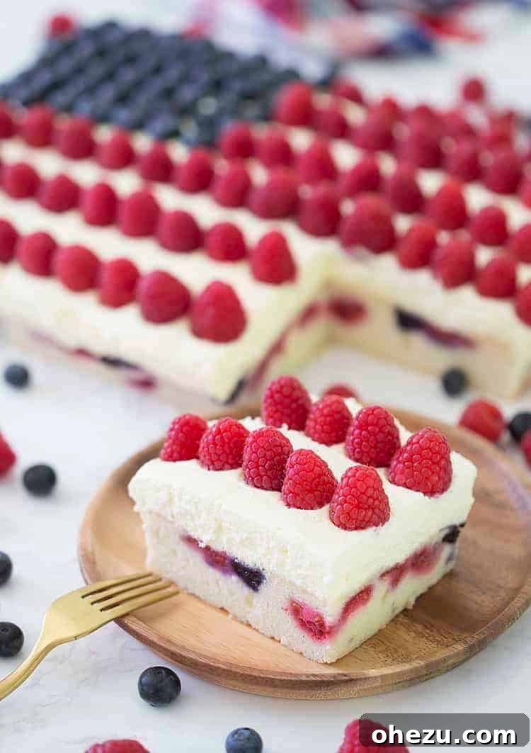 A beautifully decorated American Flag Cake with fresh berries and white frosting.