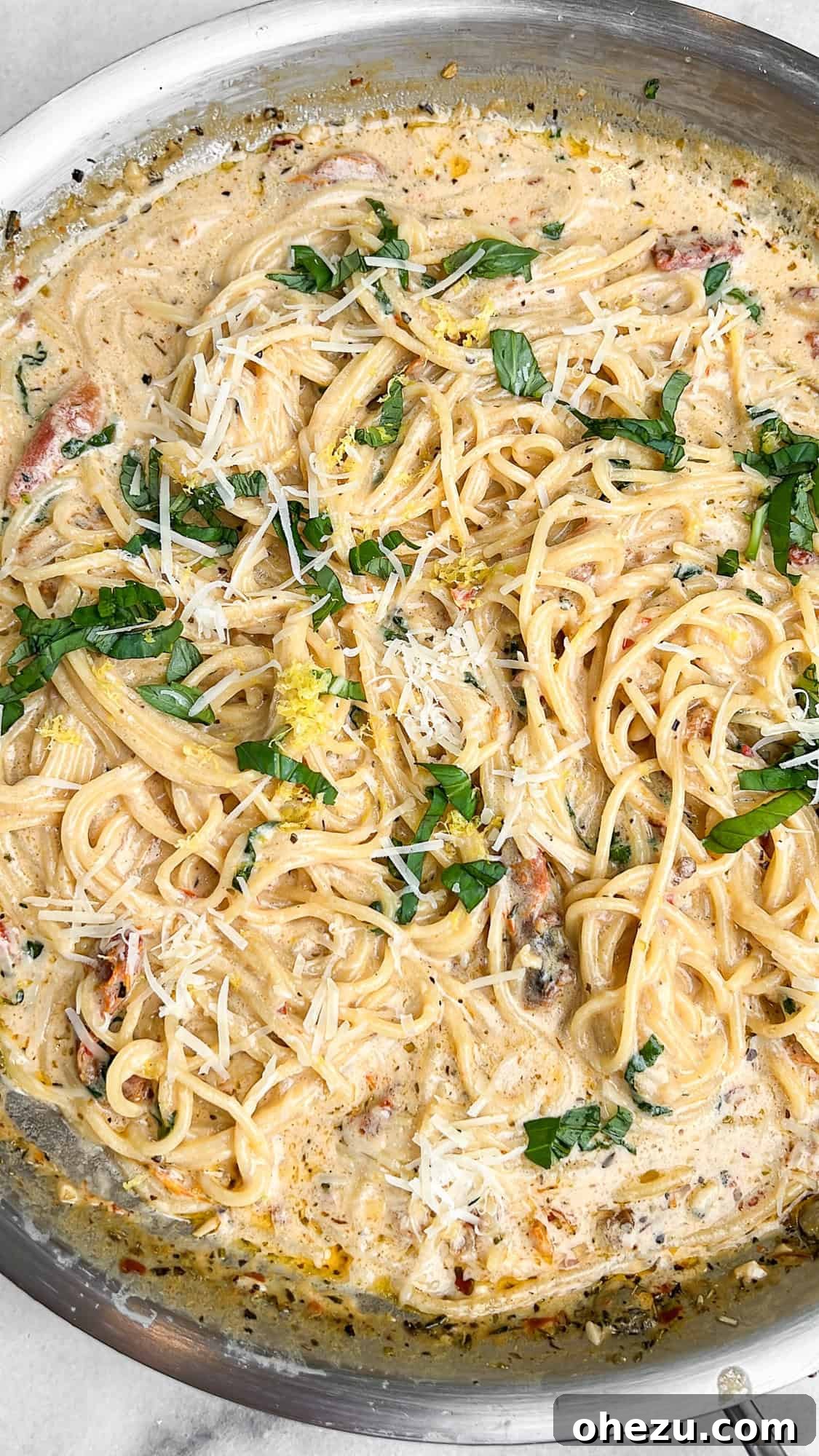 Tuscan Skillet Cream Pasta 7 Creamy Tuscan pasta served hot in a pan, garnished with fresh basil and grated Parmesan.