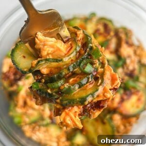 creamy peanut thai cucumber salad with chicken on a fork