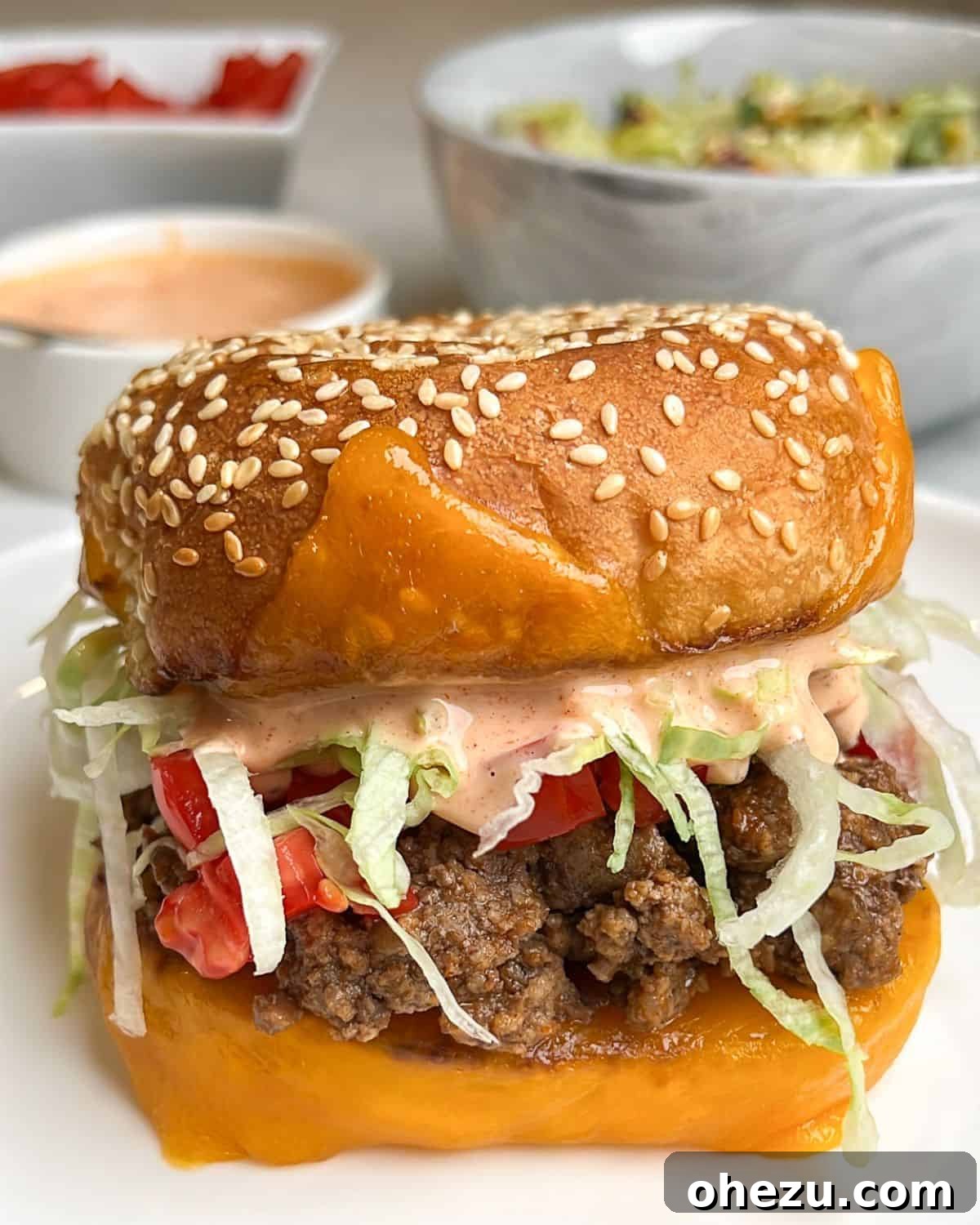 A beautifully assembled Tex-Mex Taco Burger with creamy Thousand Island dressing, served alongside a bowl of fresh slaw.