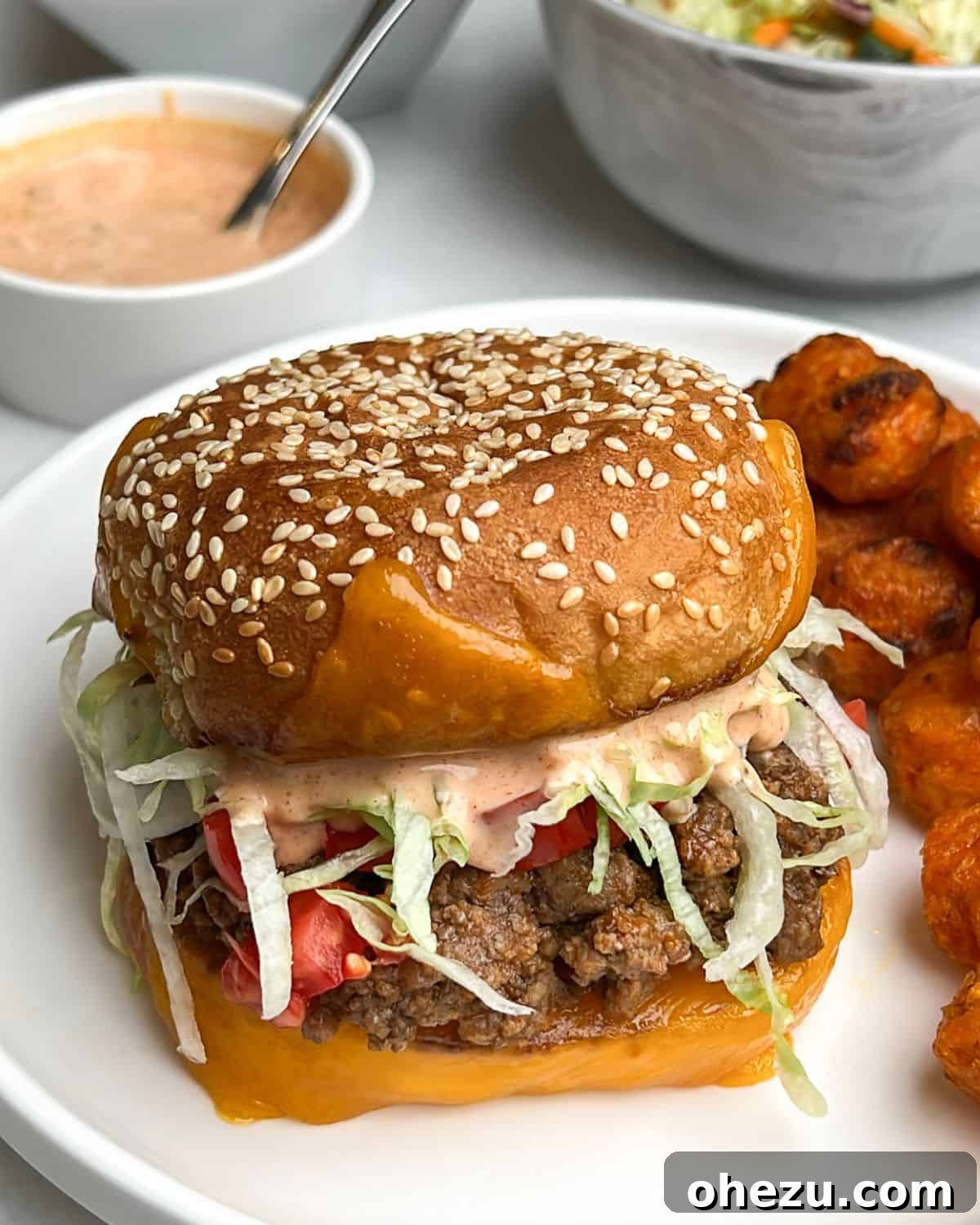 A Tex-Mex Taco Burger served on a plate with crispy French fries, ready to be enjoyed.