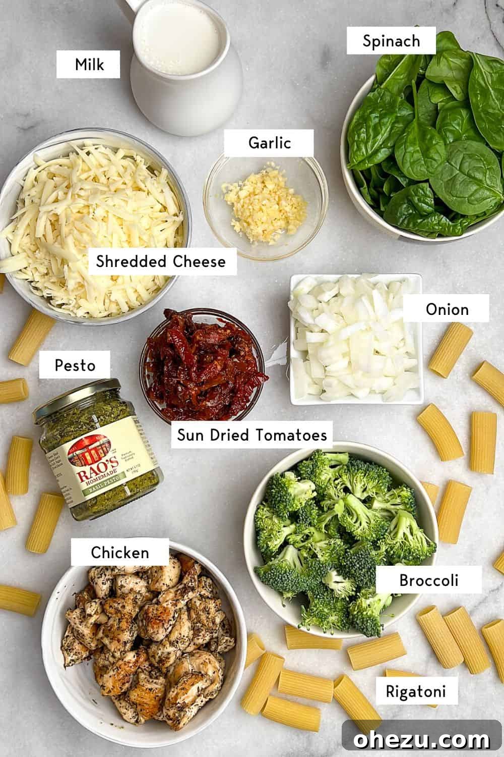 Labeled ingredients for the creamy pesto chicken pasta bake arranged neatly.