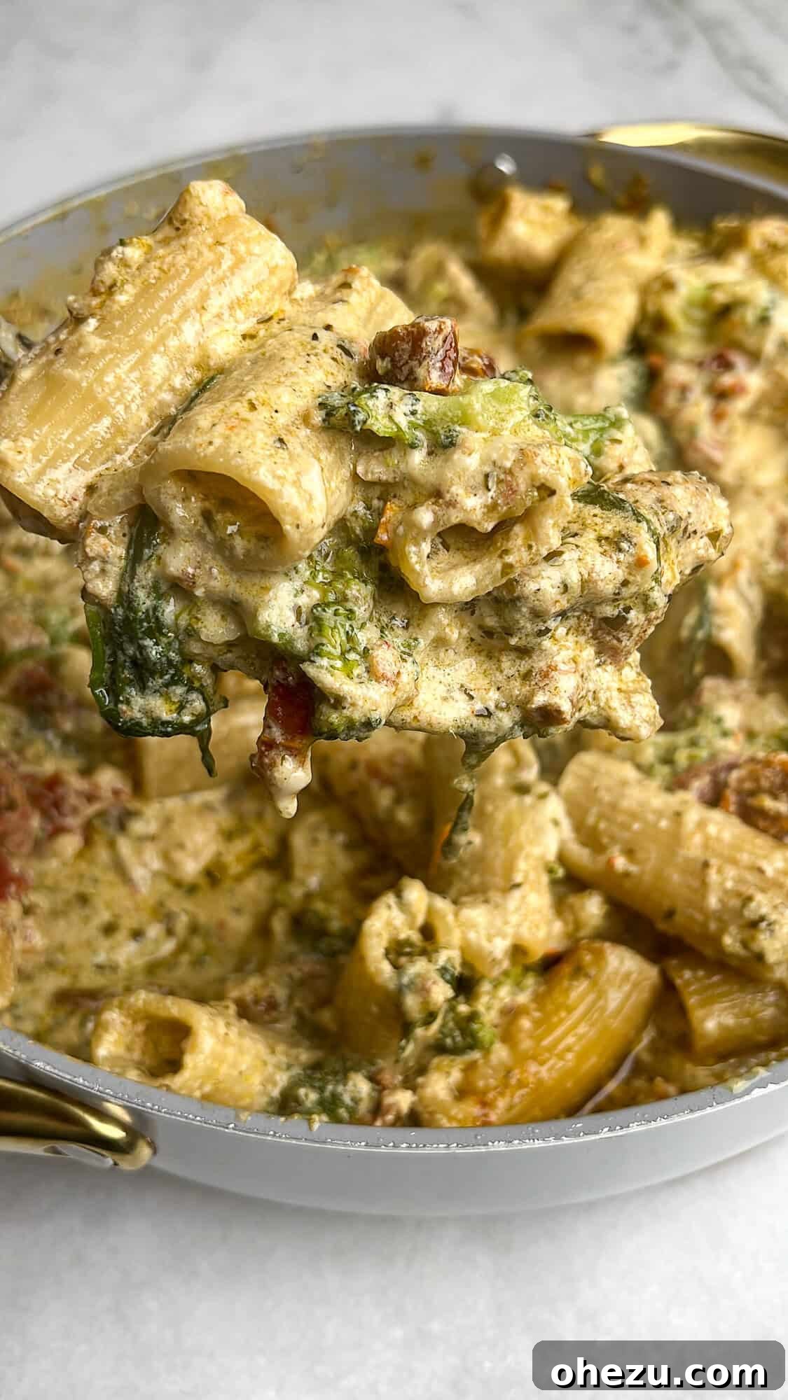 A vibrant pesto chicken pasta bake in a large cast iron skillet, ready to serve.