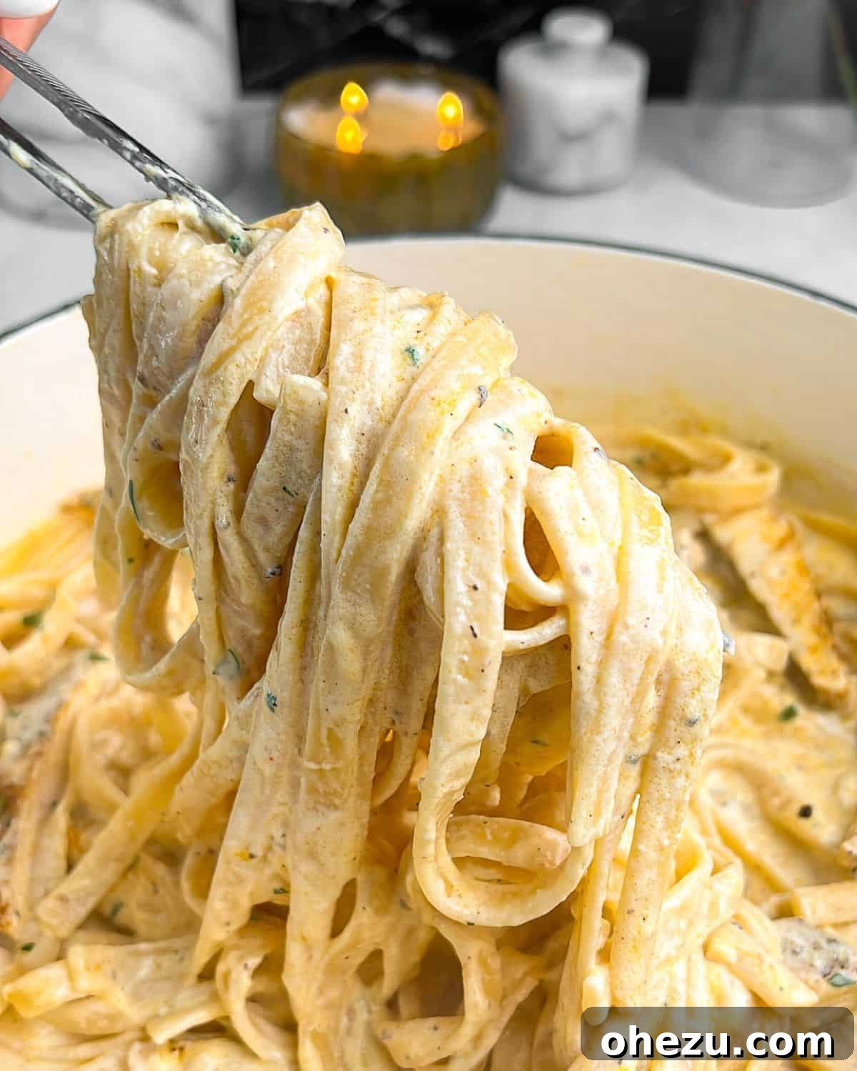 The Ultimate Creamy Chicken Alfredo 7 chicken alfredo noodles being pulled out of a pan