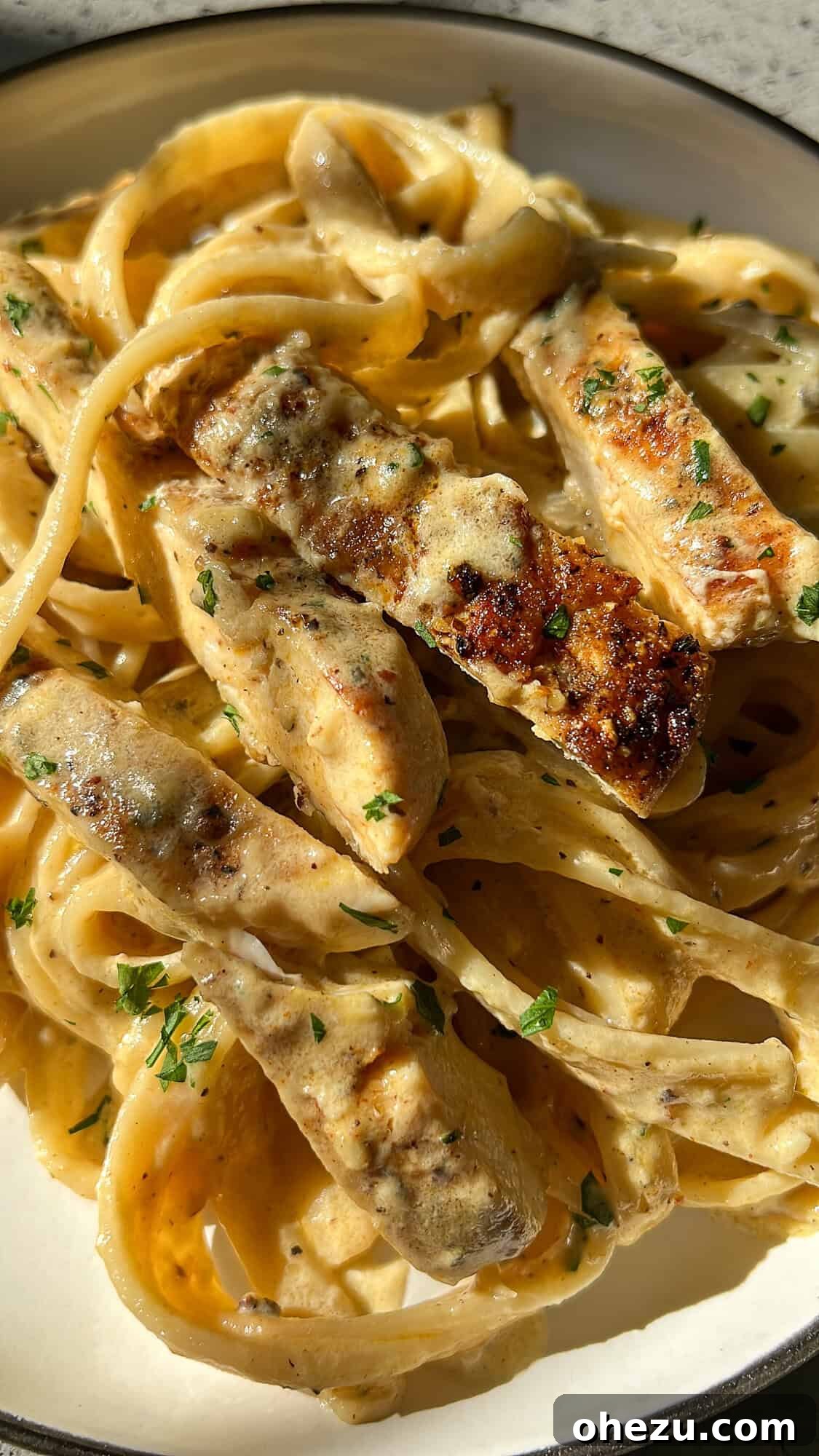 The Ultimate Creamy Chicken Alfredo 8 a plate of chicken alfredo sitting on the counter