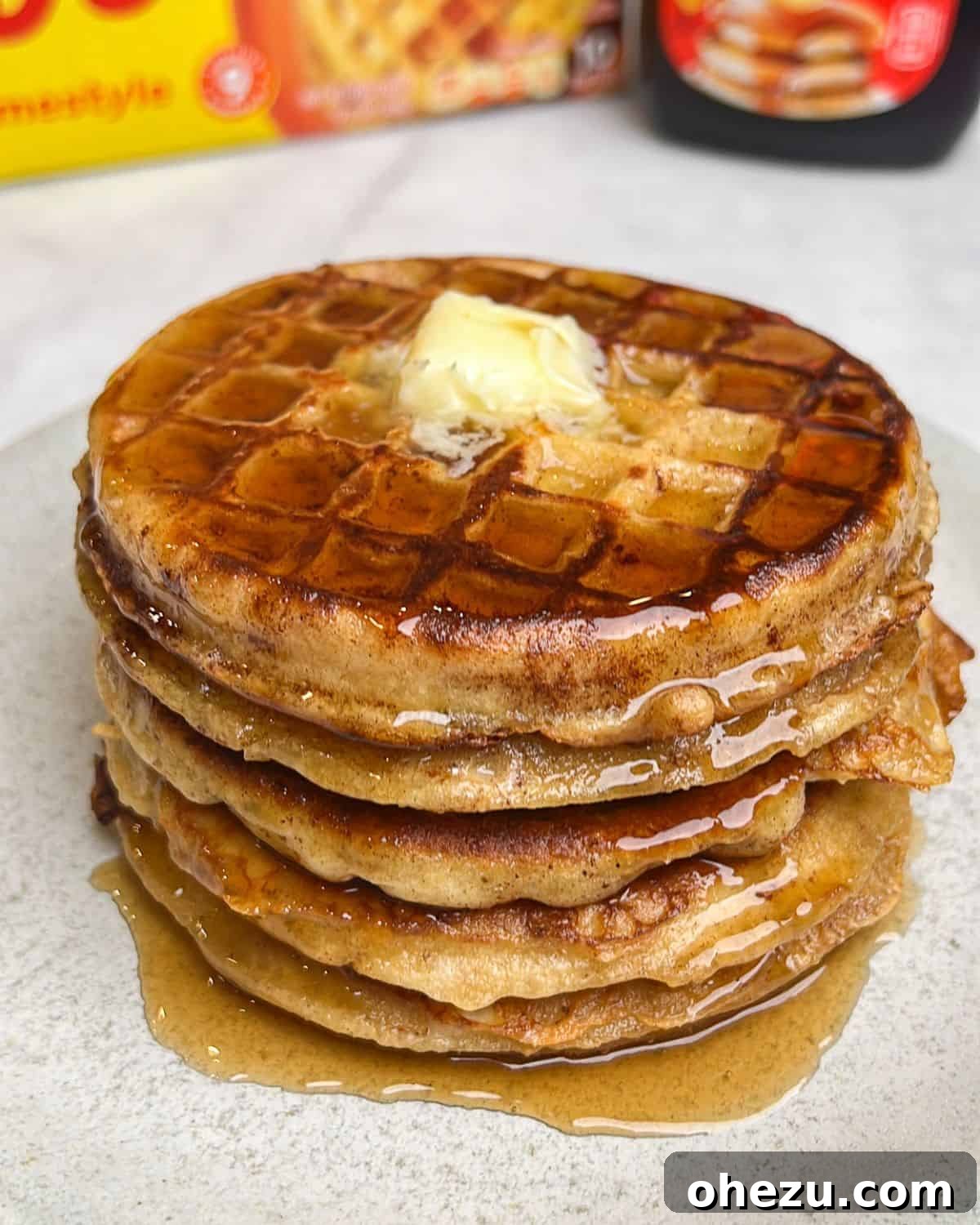 A stack of golden French toast waffles, glistening with melted butter and drizzled maple syrup, ready to be enjoyed for breakfast.