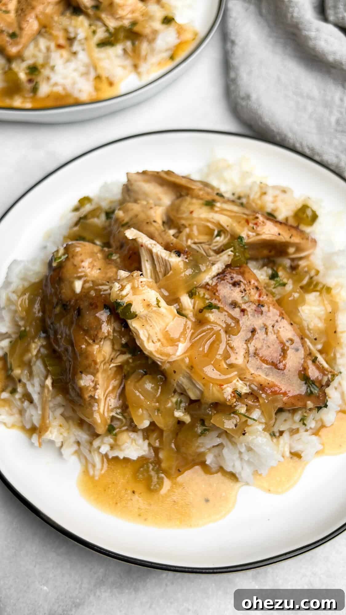 This slow cooker smothered chicken, with its creamy gravy and melt-in-your-mouth texture, is the ultimate cozy meal. And it's so easy! Slow cooker smothered chicken served generously over white rice, ready to be enjoyed as a hearty meal.