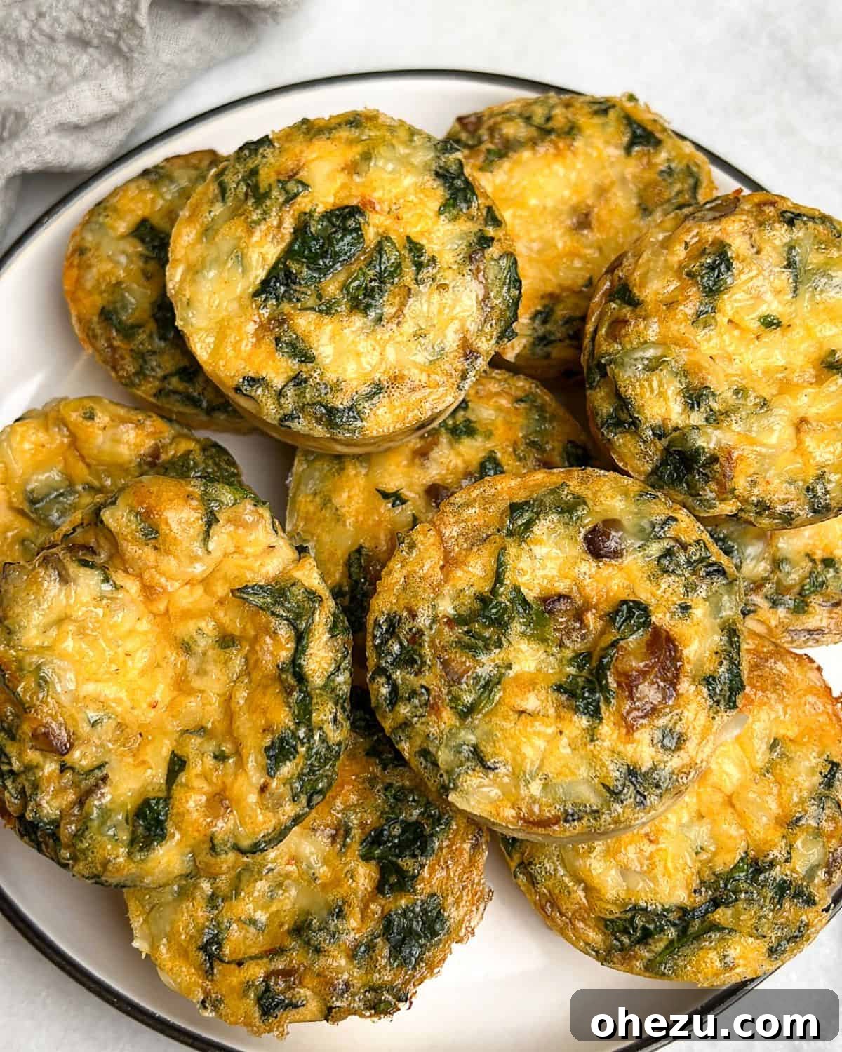 These homemade kale and mushroom egg bites offer fluffy, protein-packed goodness, inspired by the Starbucks original with gourmet upgrades! Piled high homemade kale and mushroom egg bites on a plate, ready to be enjoyed for breakfast or brunch.